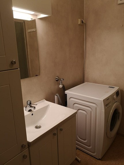 Vaskemaskin på bad. Toalett og dusj. Galleribilde