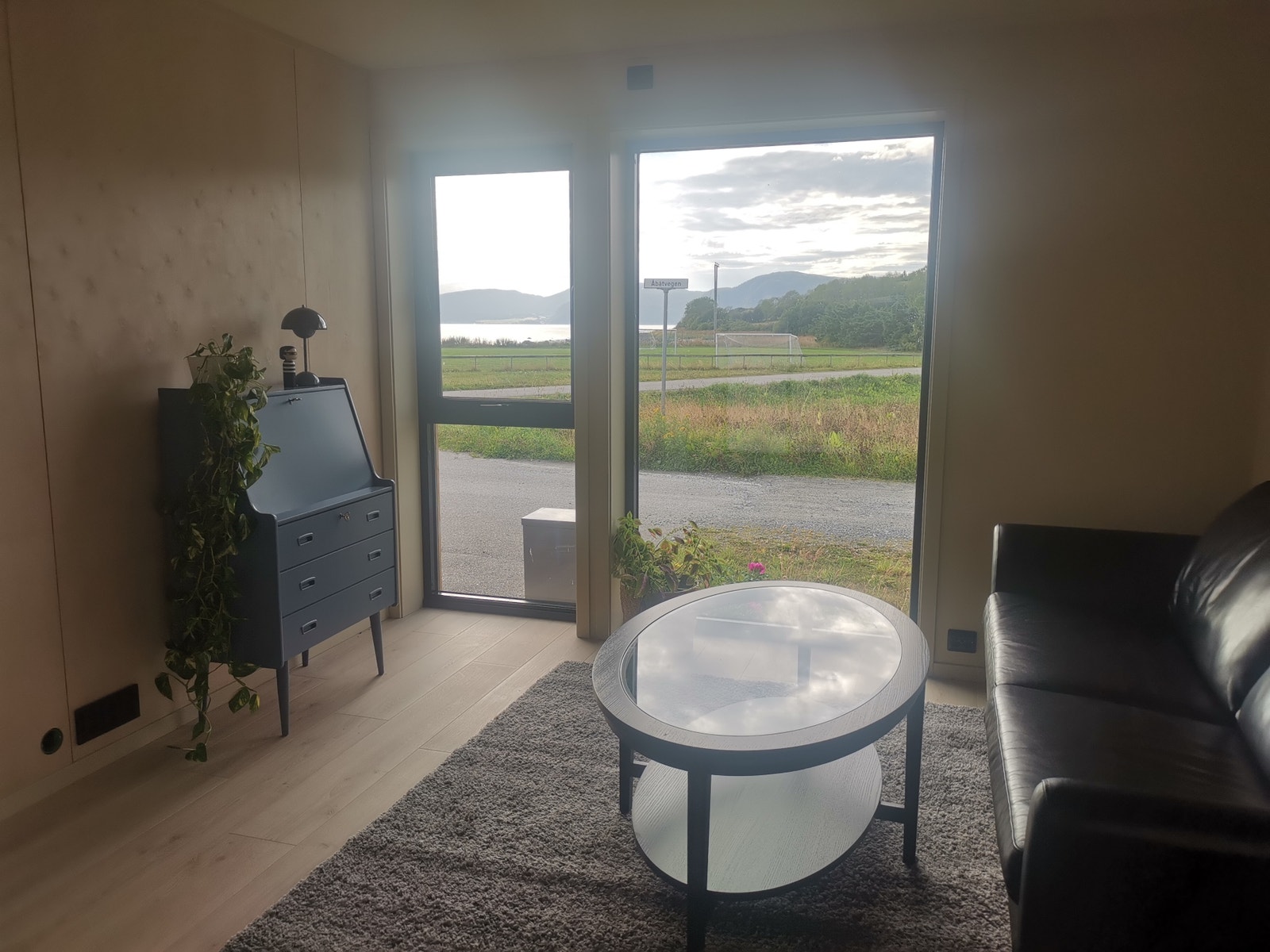 Stue med store flotte vinduer og nydelig utsikt over bukta, sjøen og Fosen alpene Galleribilde