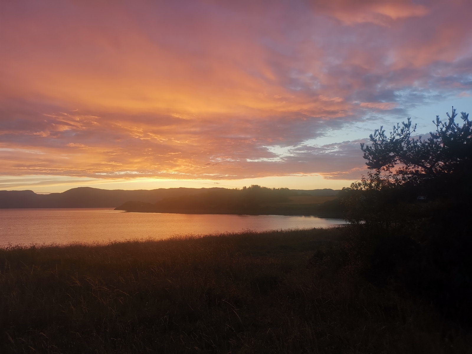 nydelig utsikt over sjøen og himmelen med alle sine flotte farger. Sjøen ligger 1 minutts gange fra leiligheten Galleribilde