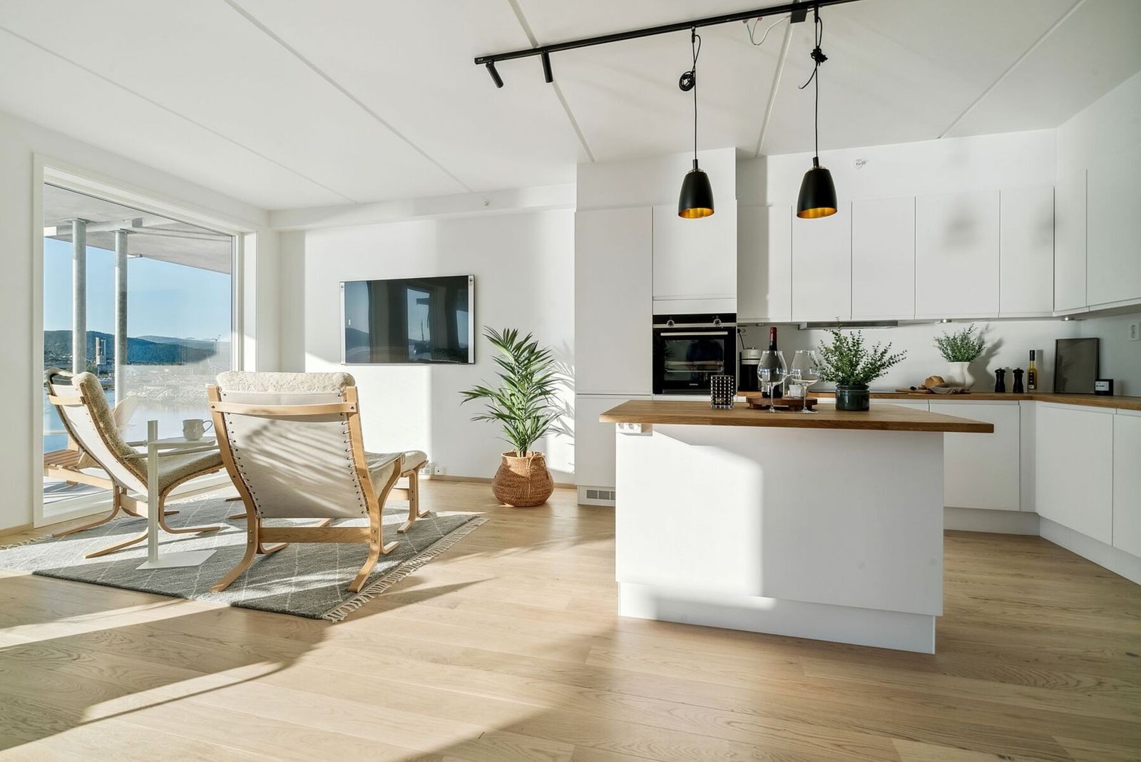 Åpen kjøkkenløsning med moderne innredning, kjøkkenøy og integrerte hvitevarer Galleribilde