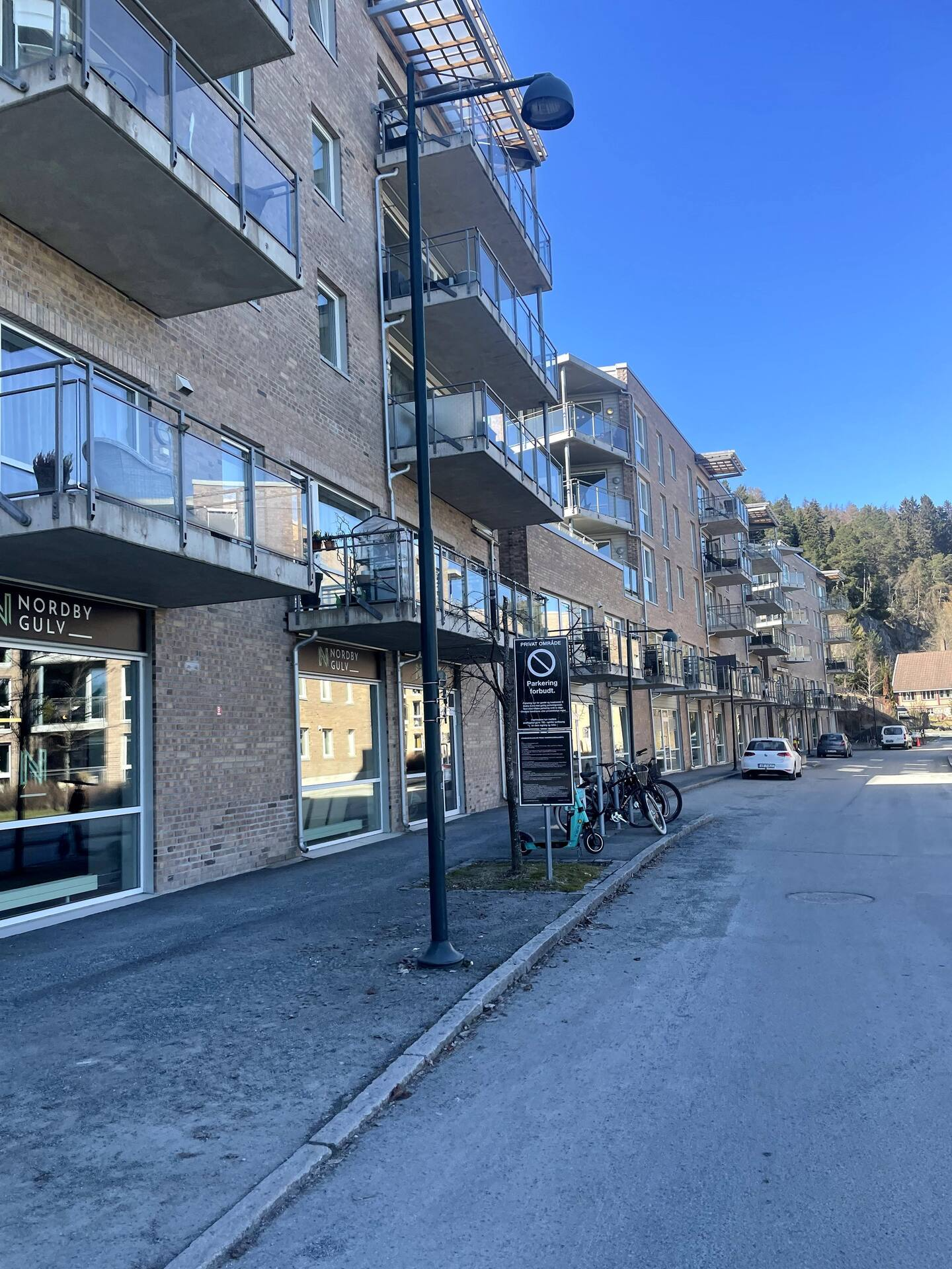 Gate/gjeste-parkering foran hovedinngang til leilighetskomplekset. Galleribilde