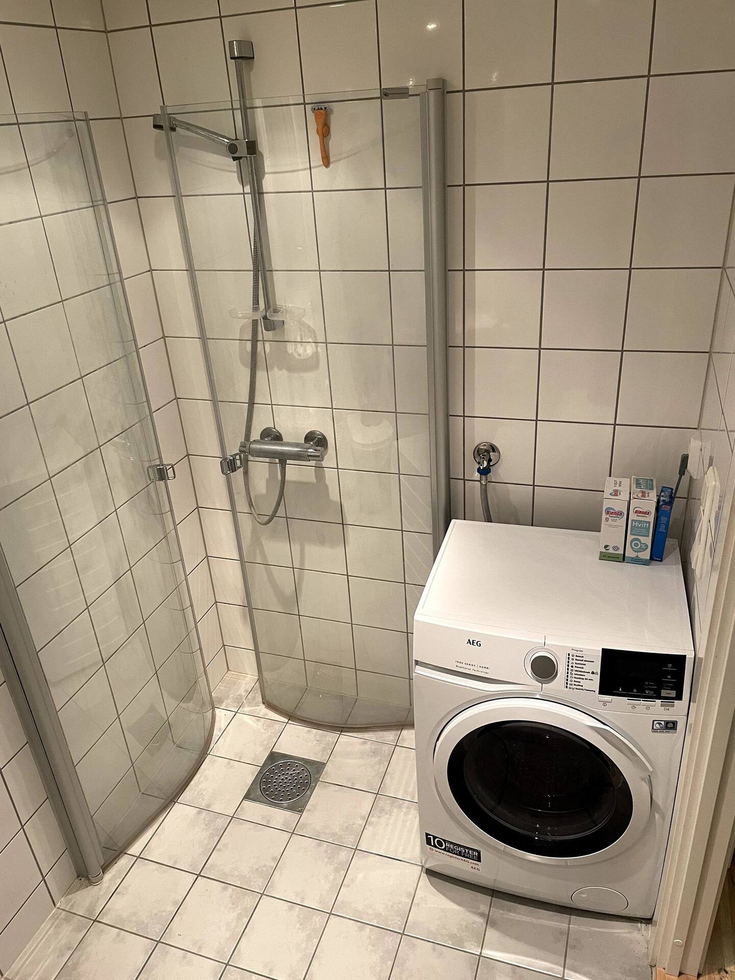 Toalett med dusj og kombivaskemaskin Galleribilde