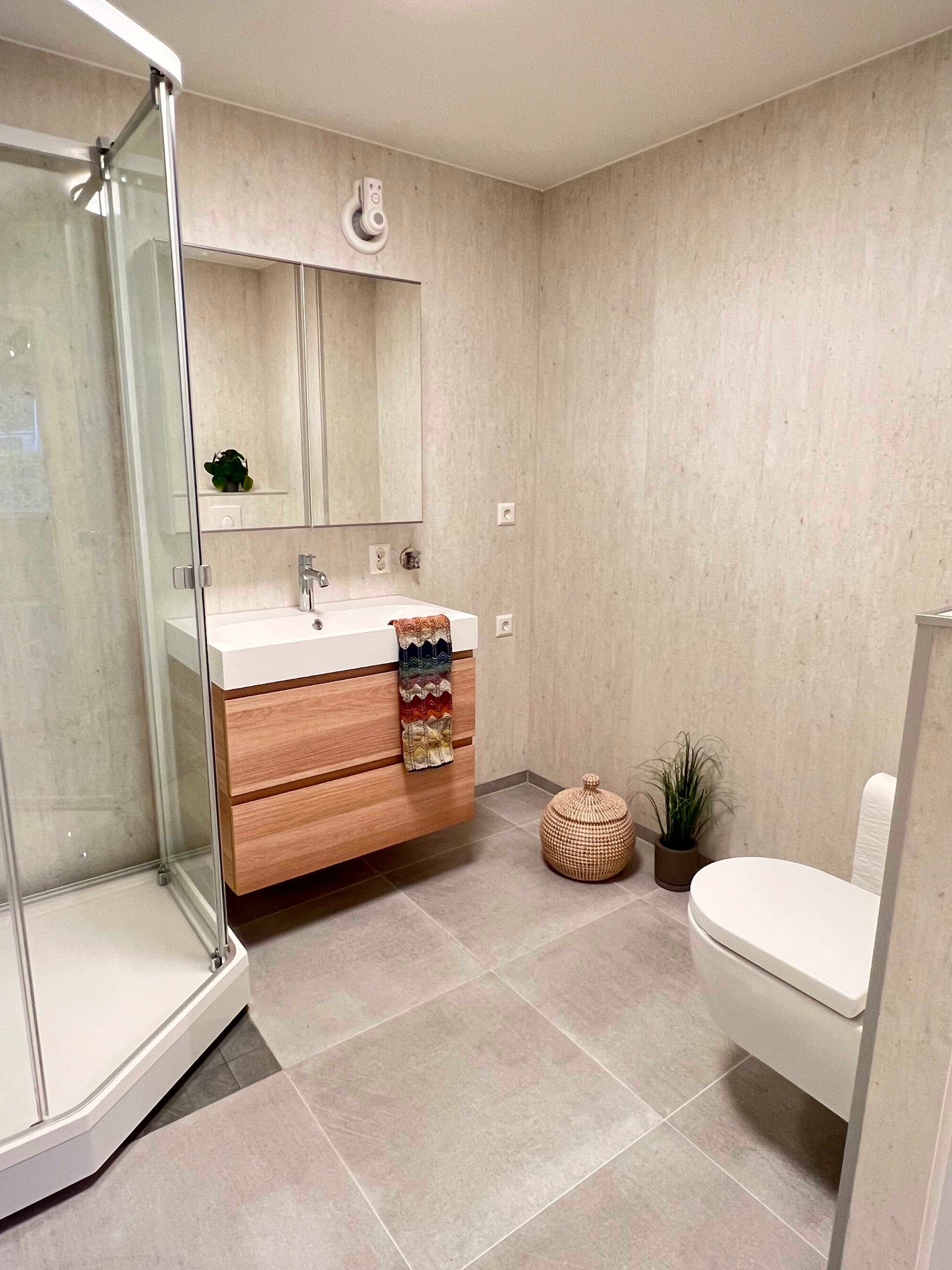 Nyoppusset bad med vegghengt toalett, dusjkabinett og klargjort for vaskemaskin og tørketrommel i søyle Galleribilde