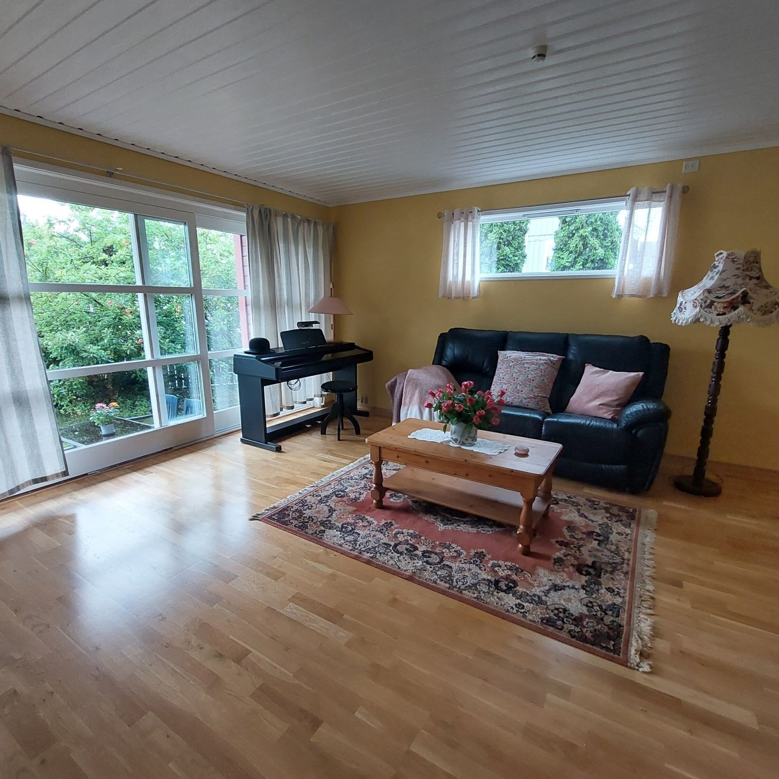 Stor stue med utsikt til hage og epletre Galleribilde