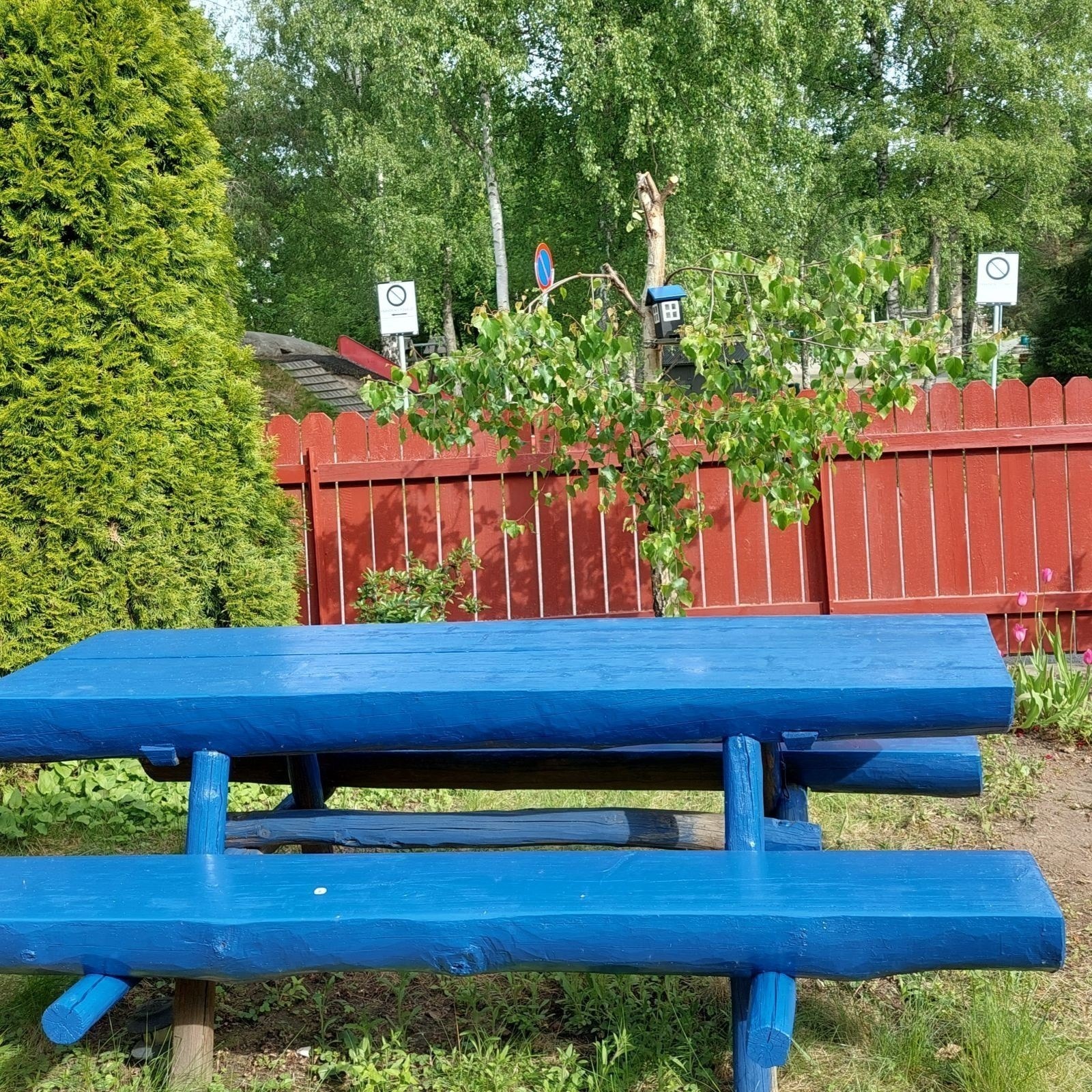 En koselig hagebenk med utsikt til sklien på lekeplassen Galleribilde