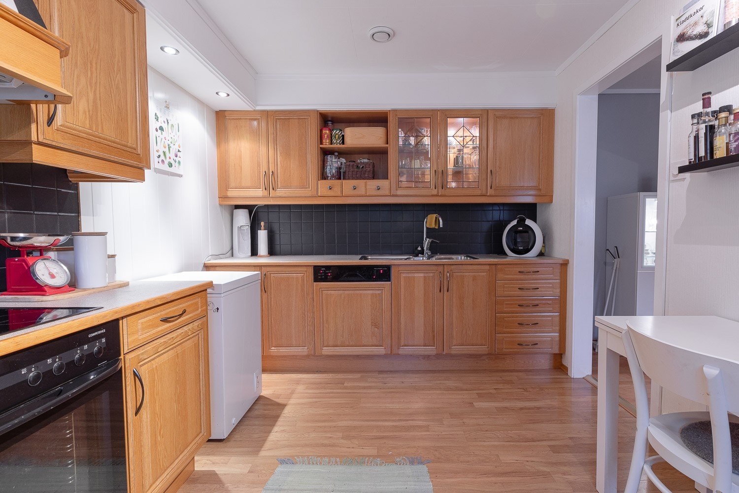 Kjøkken på 12kvm med integrert komfyr, stekeplate, oppvaskmaskin og kjøleskap. Frittstående fryser Galleribilde