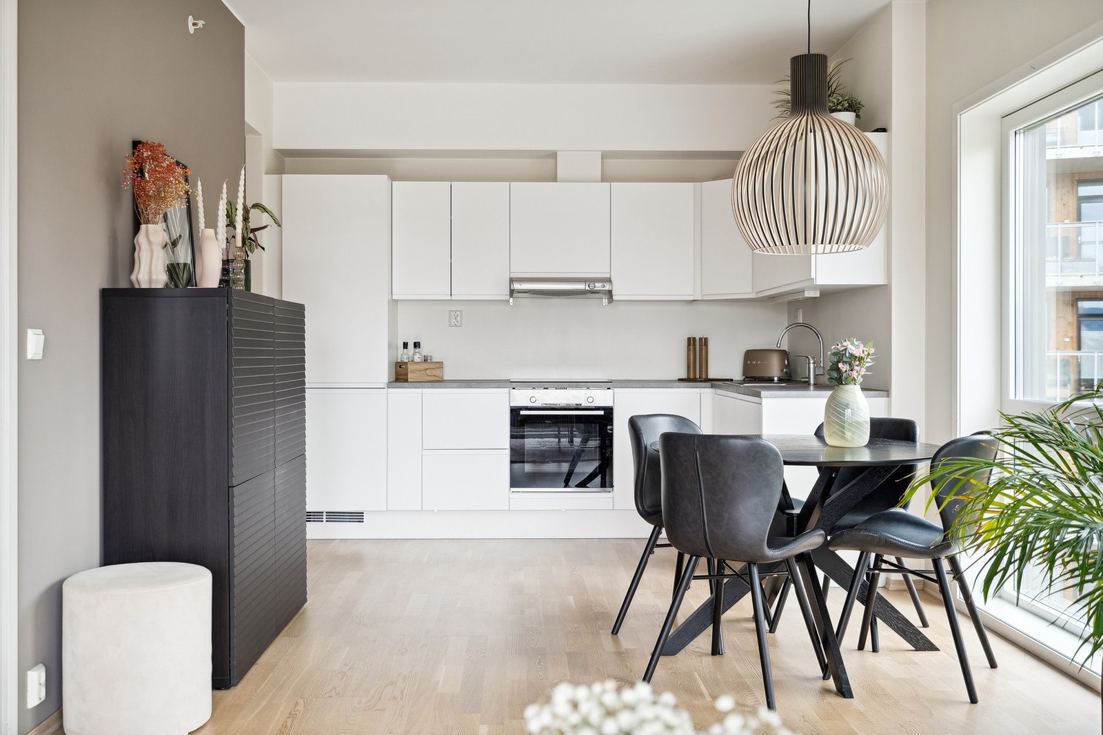 Lyst og moderne hjørnekjøkken med integrerte hvitevarer. Galleribilde