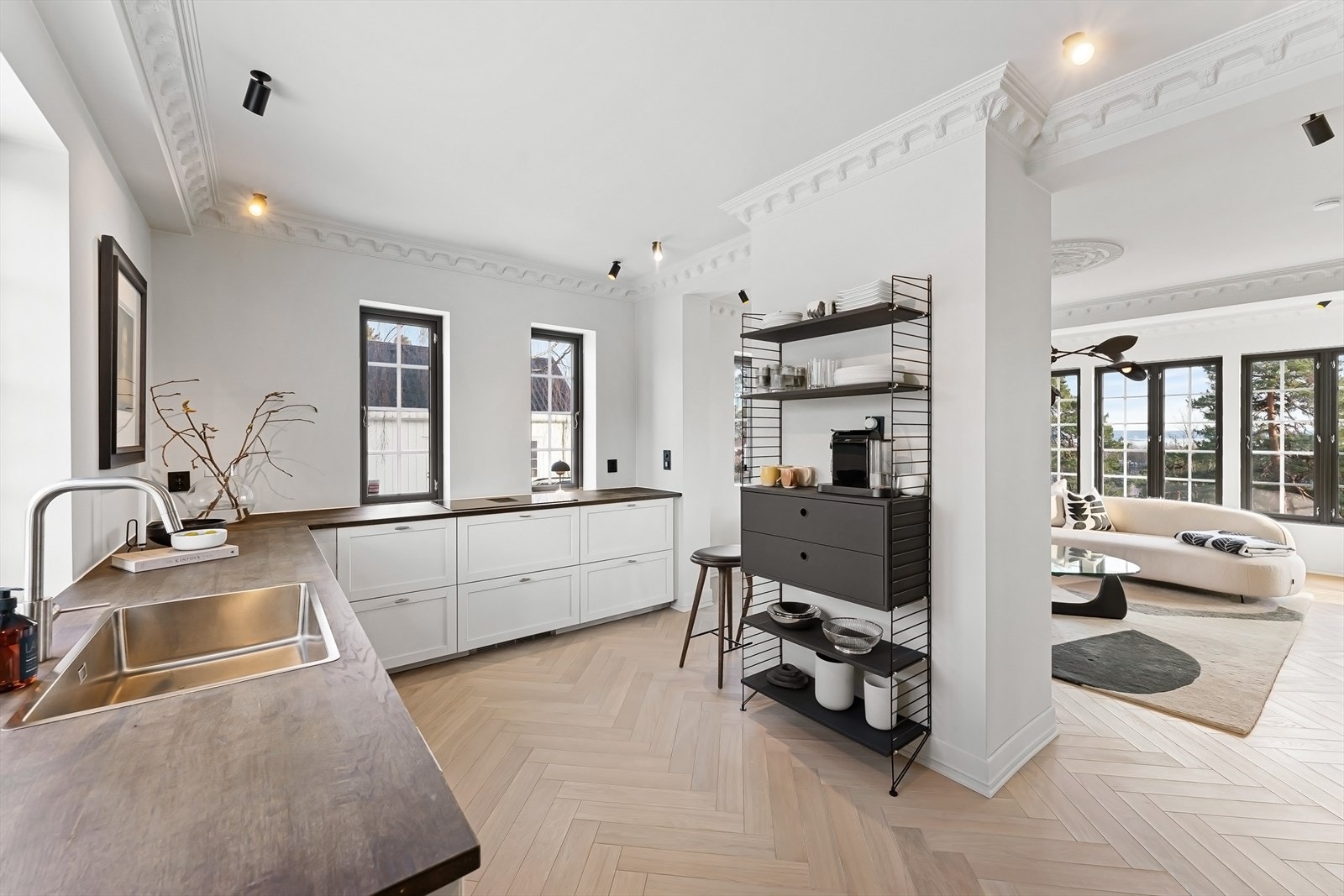 Kjøkkenet har stor moderne innredning med glatte malte ramtrefronter. Heltre benkeplater med nedfelt vaskekum og keramisk platetopp med integrert avtrekksvifte. Galleribilde