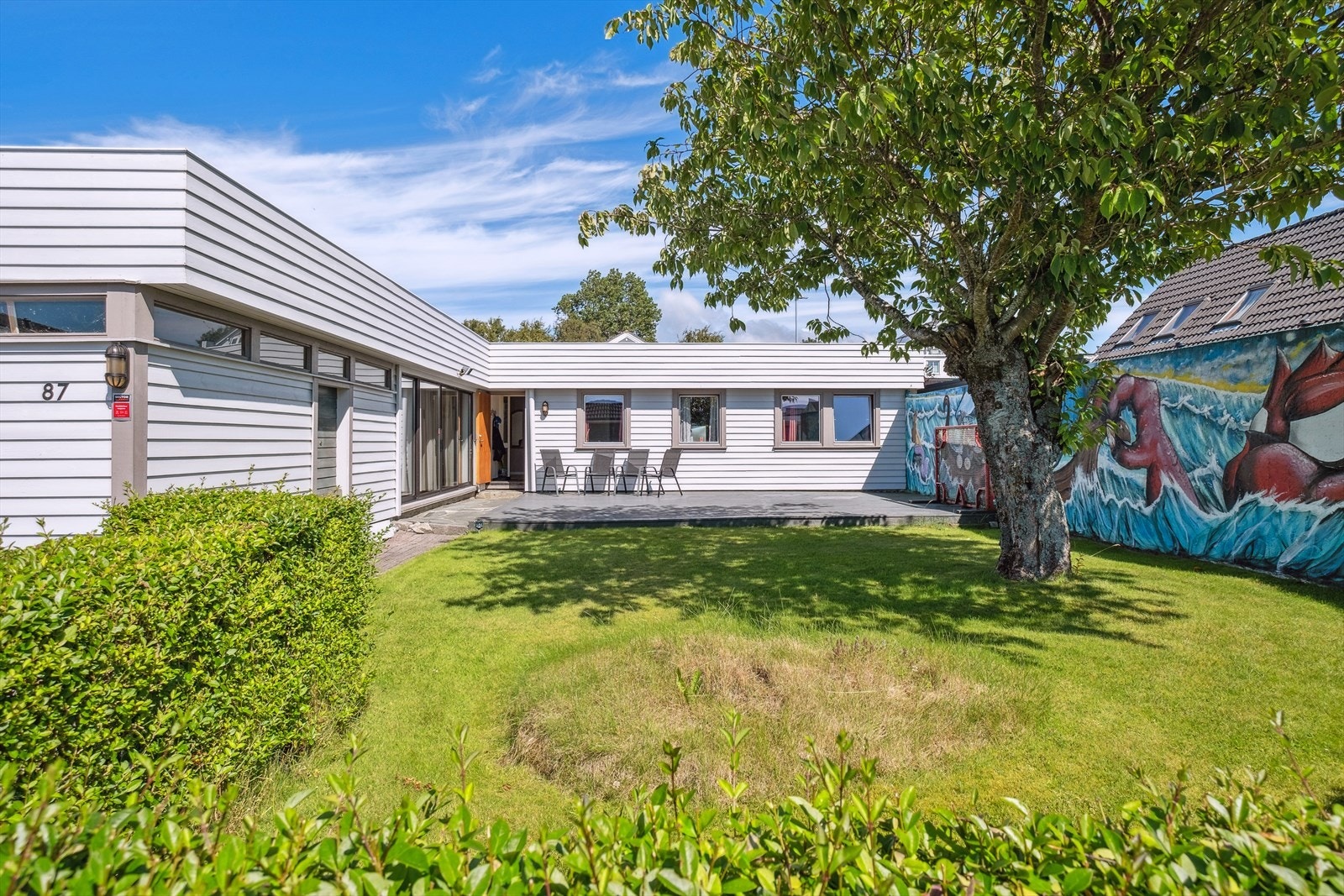 Uteområdet er lunt og avskjermet med hekk og murvegg Galleribilde