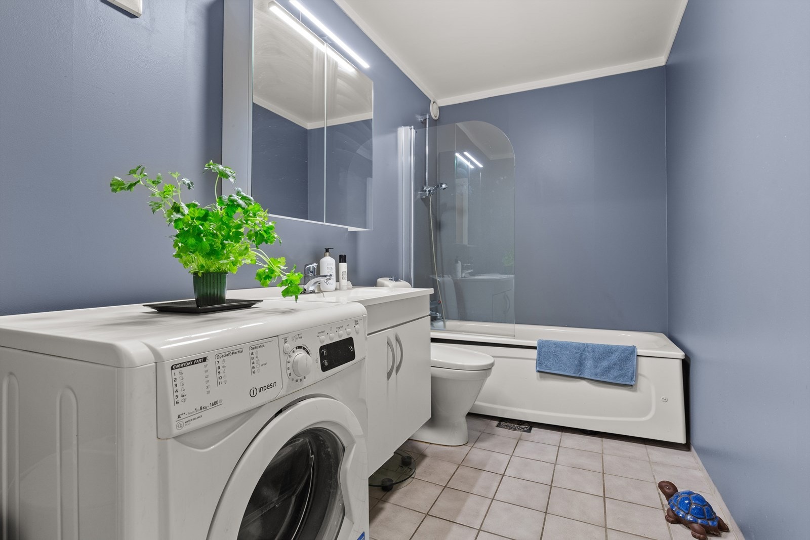 Badet er malte flater på vegg og fliser på gulv. Galleribilde