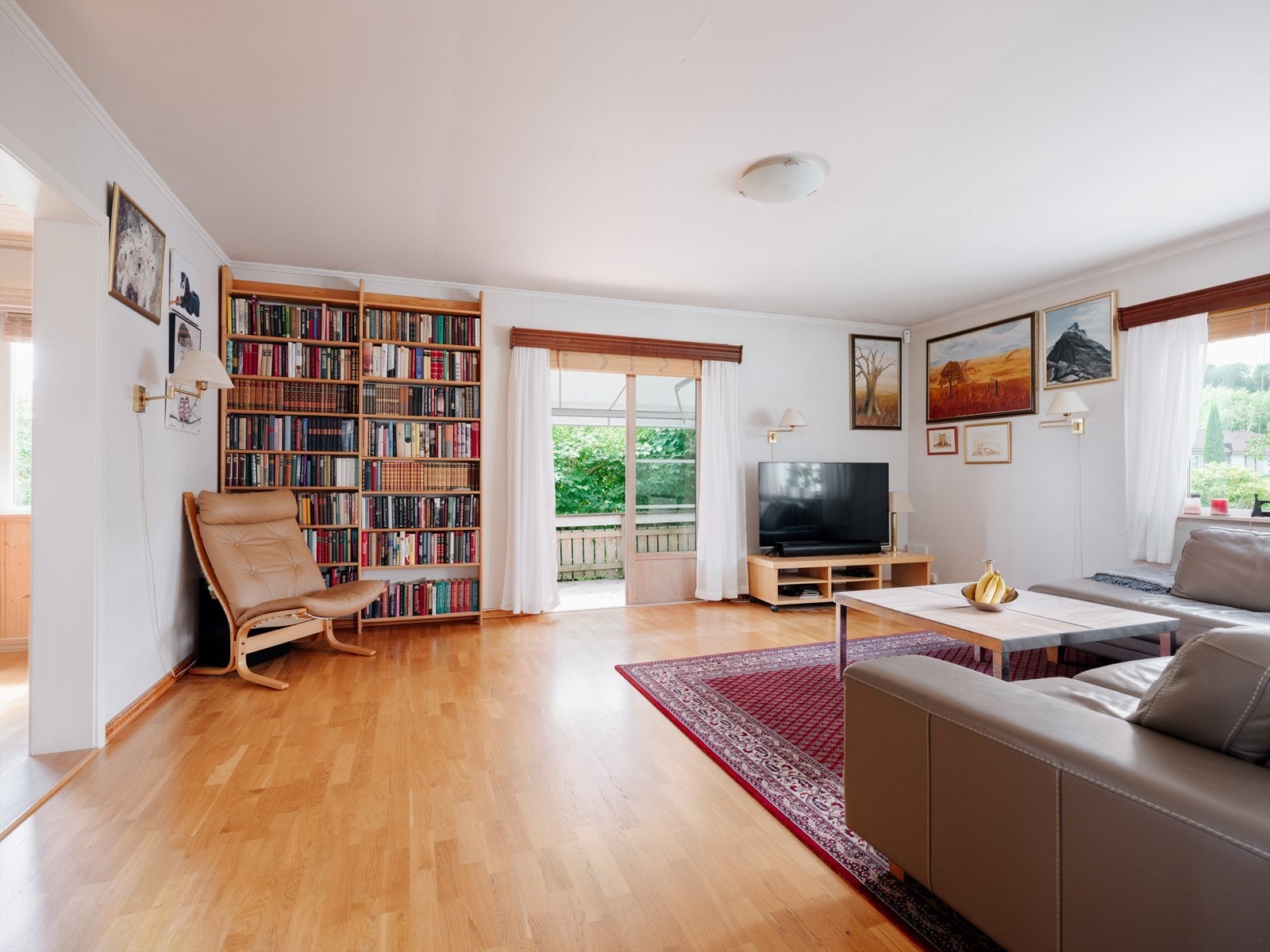 Lys stue med store vindusflater som slipper inn godt med naturlig lys. Galleribilde