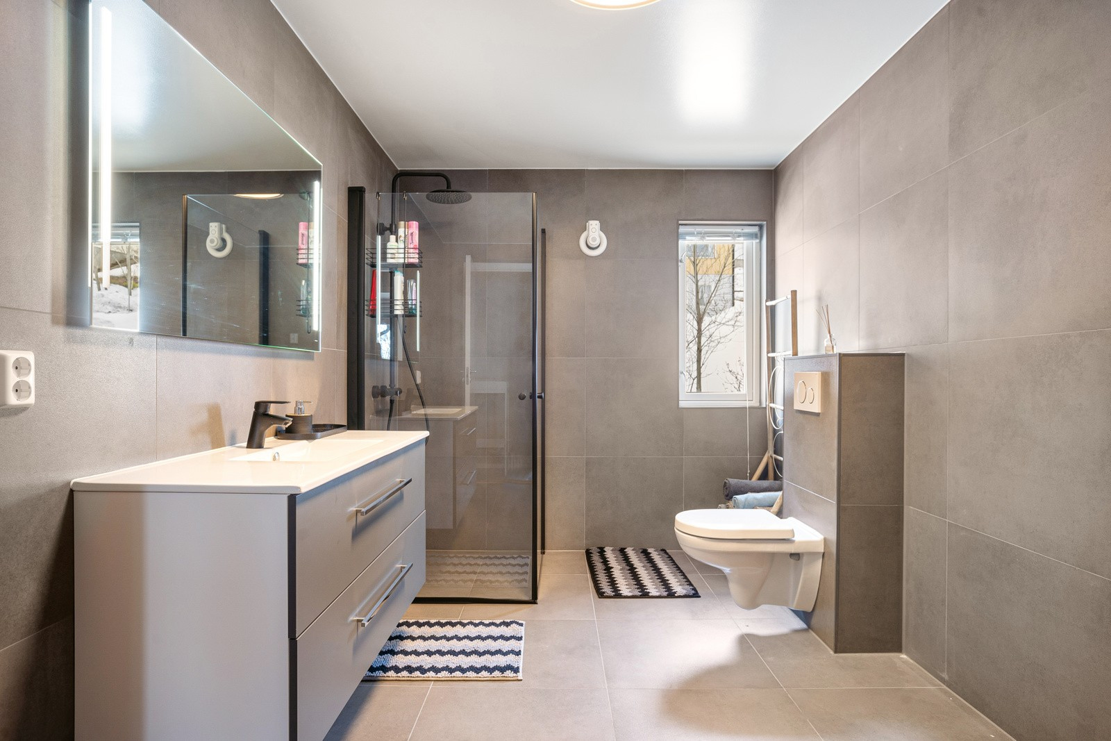 Badet er romslig og komplett flislagt og har opplegg til vaskemaskin