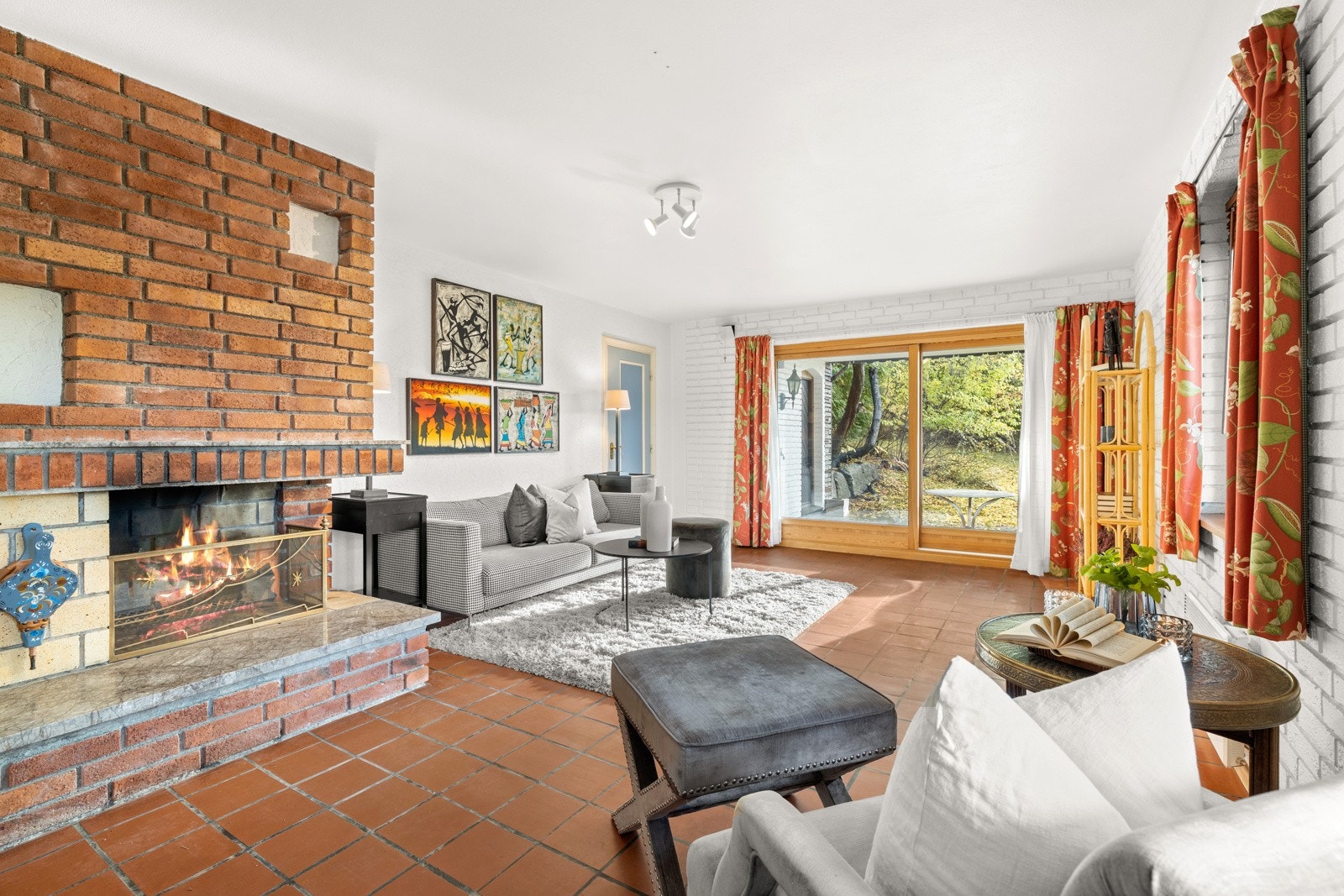 Peisestuen har flislagte gulv og åpen peis Galleribilde