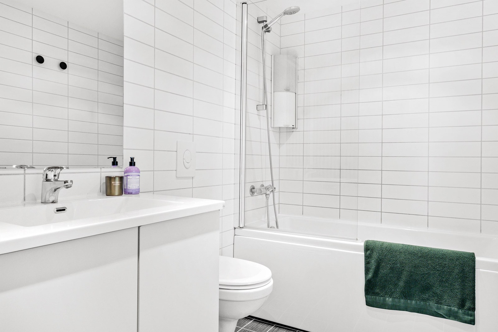 Fint baderom med opplegg for vaskemaskin, tørketrommel og det er installert badekar Galleribilde