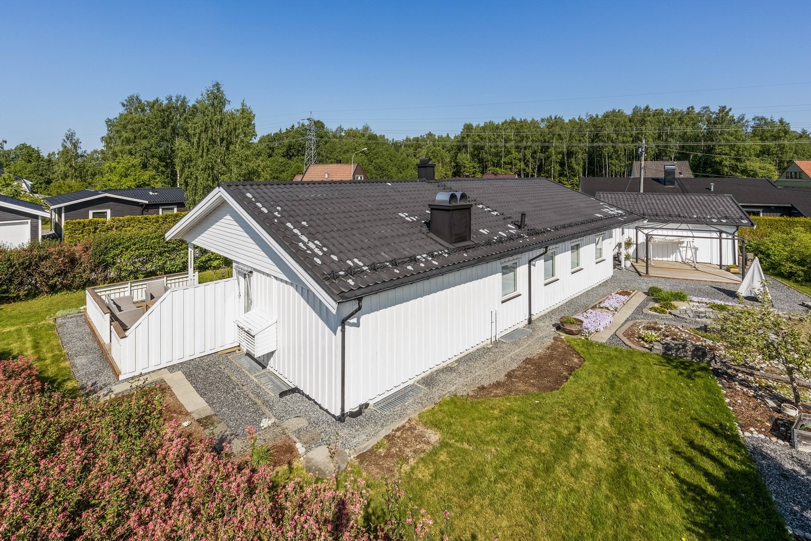 Flat og fin tomt på 1.209 m² pent opparbeidet med gruset gårdsplass, plen og diverse beplantning som planter, blomster, frukttrær, bringebær og blåbær. Galleribilde