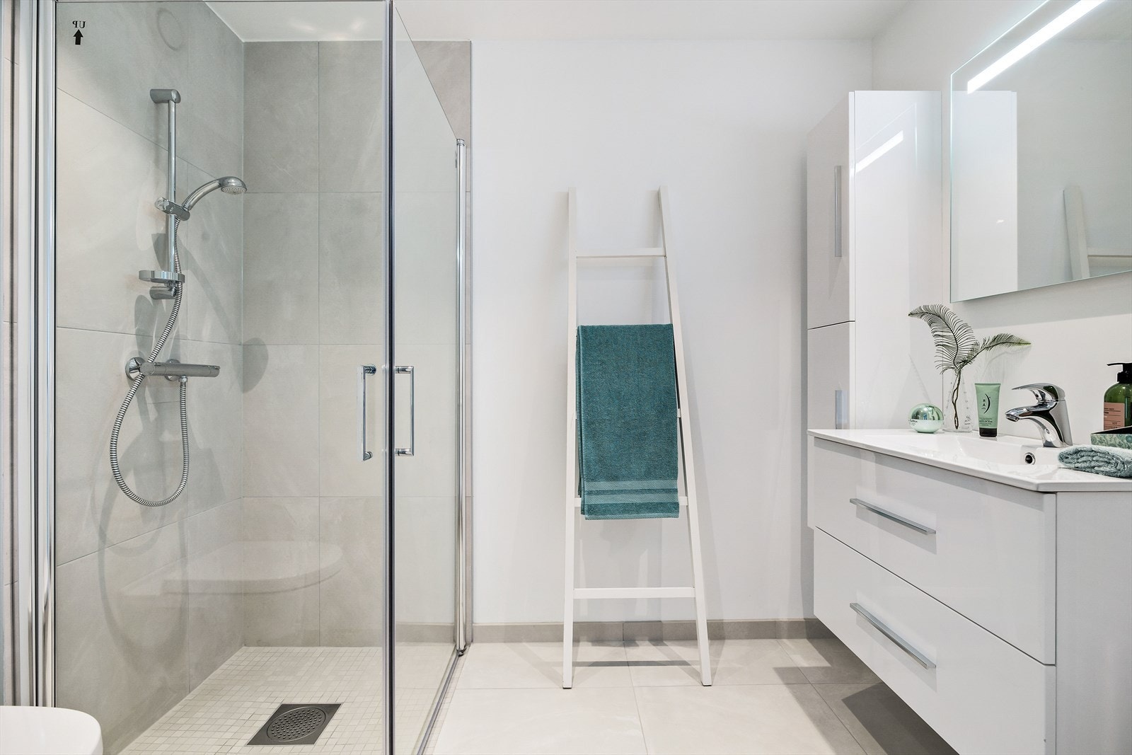 Badet er lyst og pent. Her er det dusjhjørne, servant med god oppbevaringsplass og toalett. Galleribilde