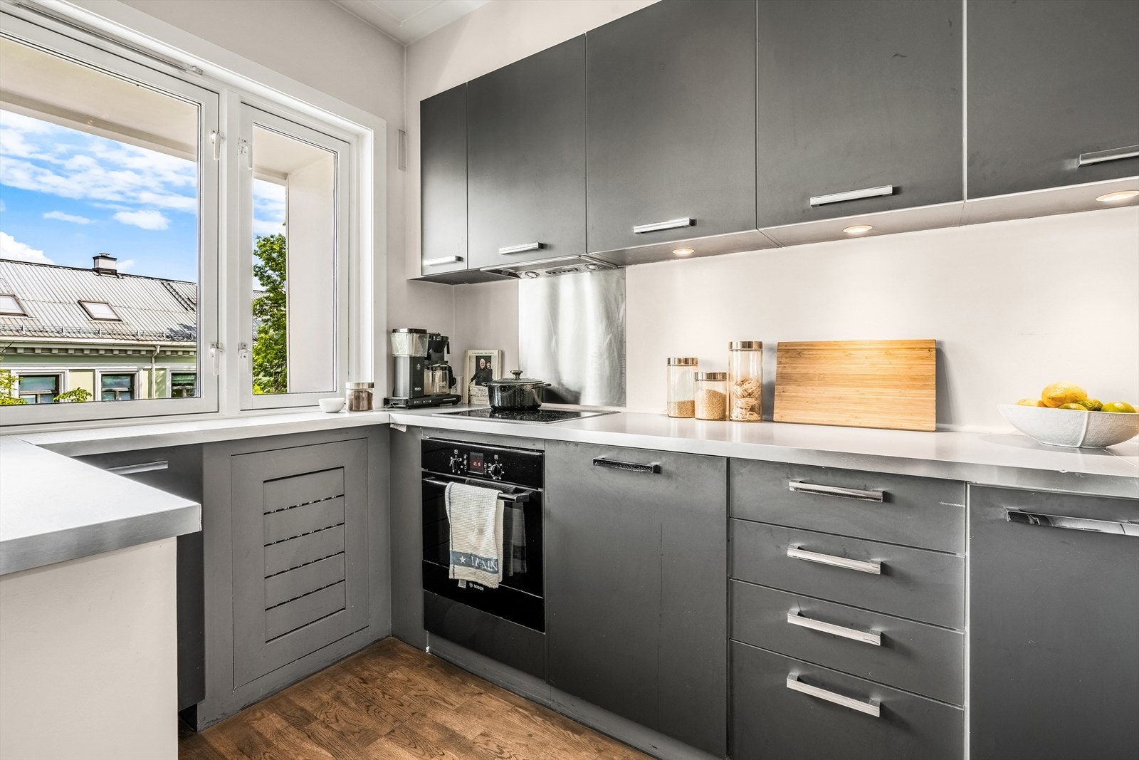 Laminatbenkeplate med nedfelt oppvaskkum og armatur. Integrerte hvitevarer som stekeovn, oppvaskmaskin og platetopp med mekanisk avtrekk. Frittstående fryser- og kjøleskap. Galleribilde