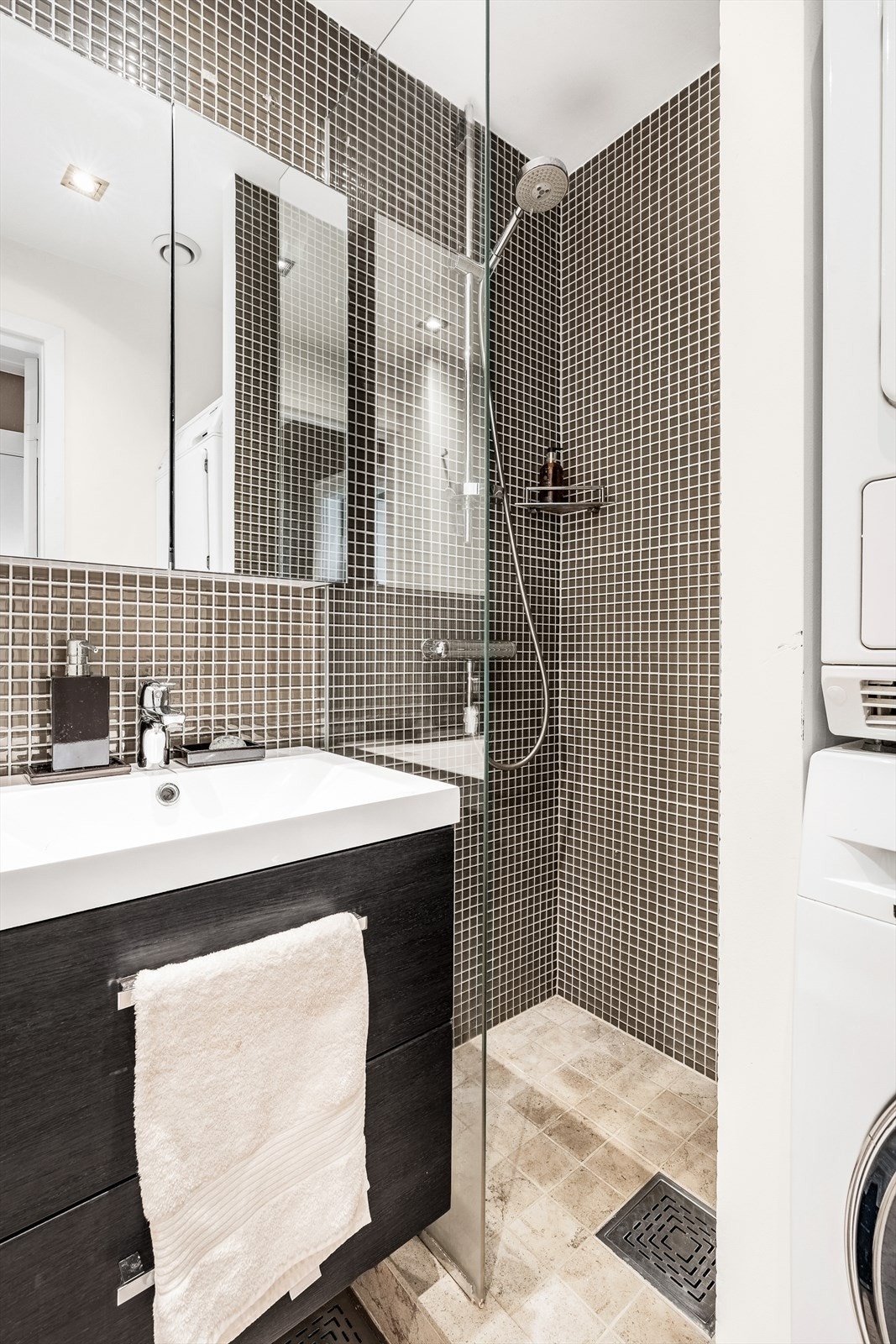 Vegghengt wc, servant med underskap samt speilskap over. Dusjhjørne med regn- samt hånddusj. Galleribilde