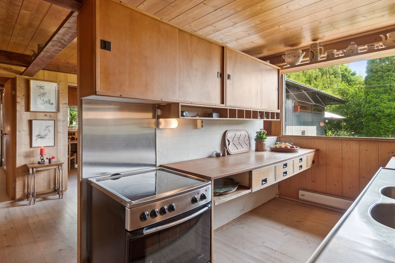 Det originale kjøkkenet fra byggeåret har et flott særpreg og er en romdeler mot den hyggelige spiseplassen bakenfor innredningen. Galleribilde