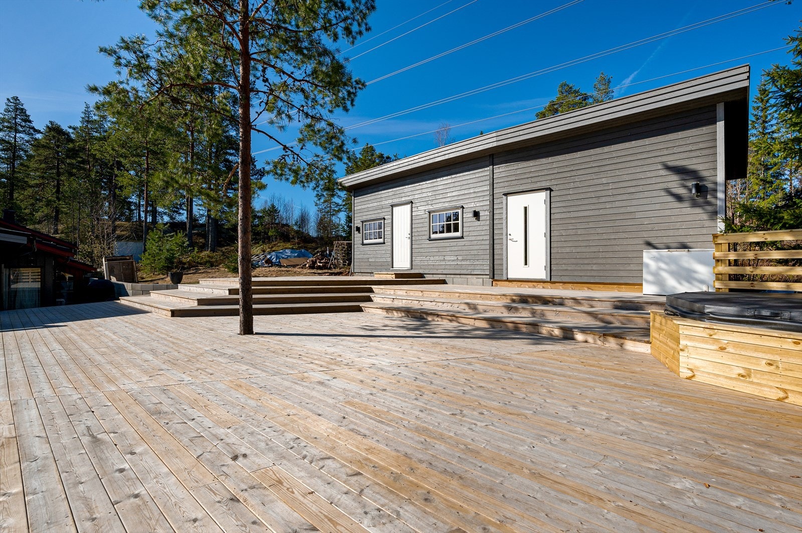 Anneks oppført i bindingsverk, fasader med malt kledning, vindu med malte karmer, malte dører, tak tekket med papp. Galleribilde