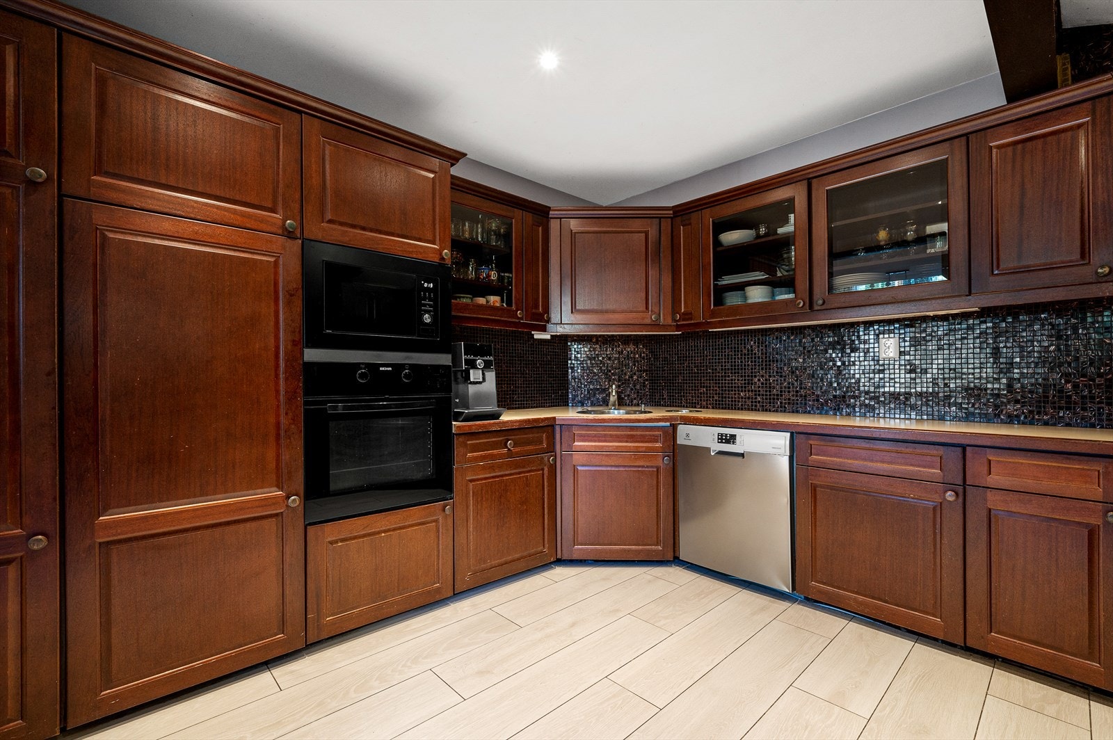 Profilert innredning samt noen fronter med glass, mosaikkfliser, laminat benkeplate keramisk topp, integrert komfyr, oppvaskmaskin og nisje for kjøl/frys. Galleribilde