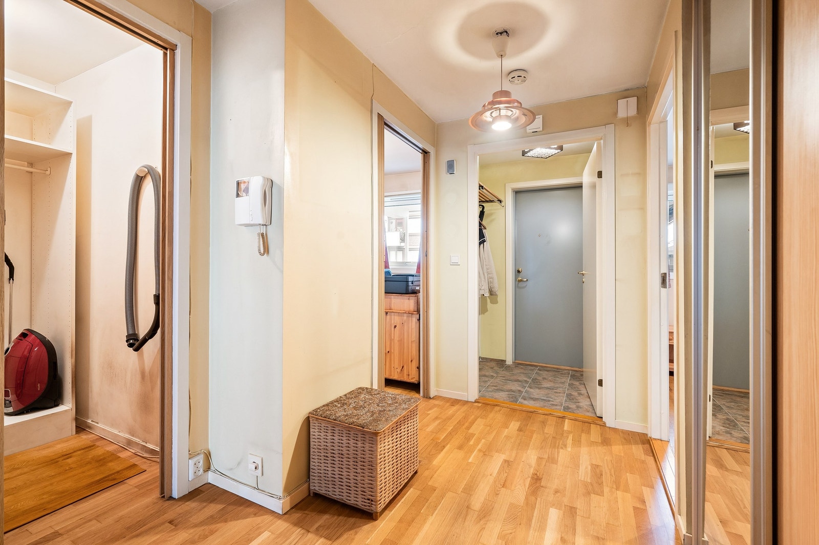 Videre innover fra entréen er det en lys og romslig gang med callinganlegg med videofunksjon, og god plass til oppbevaring i skyvedørsgarderobe. Galleribilde