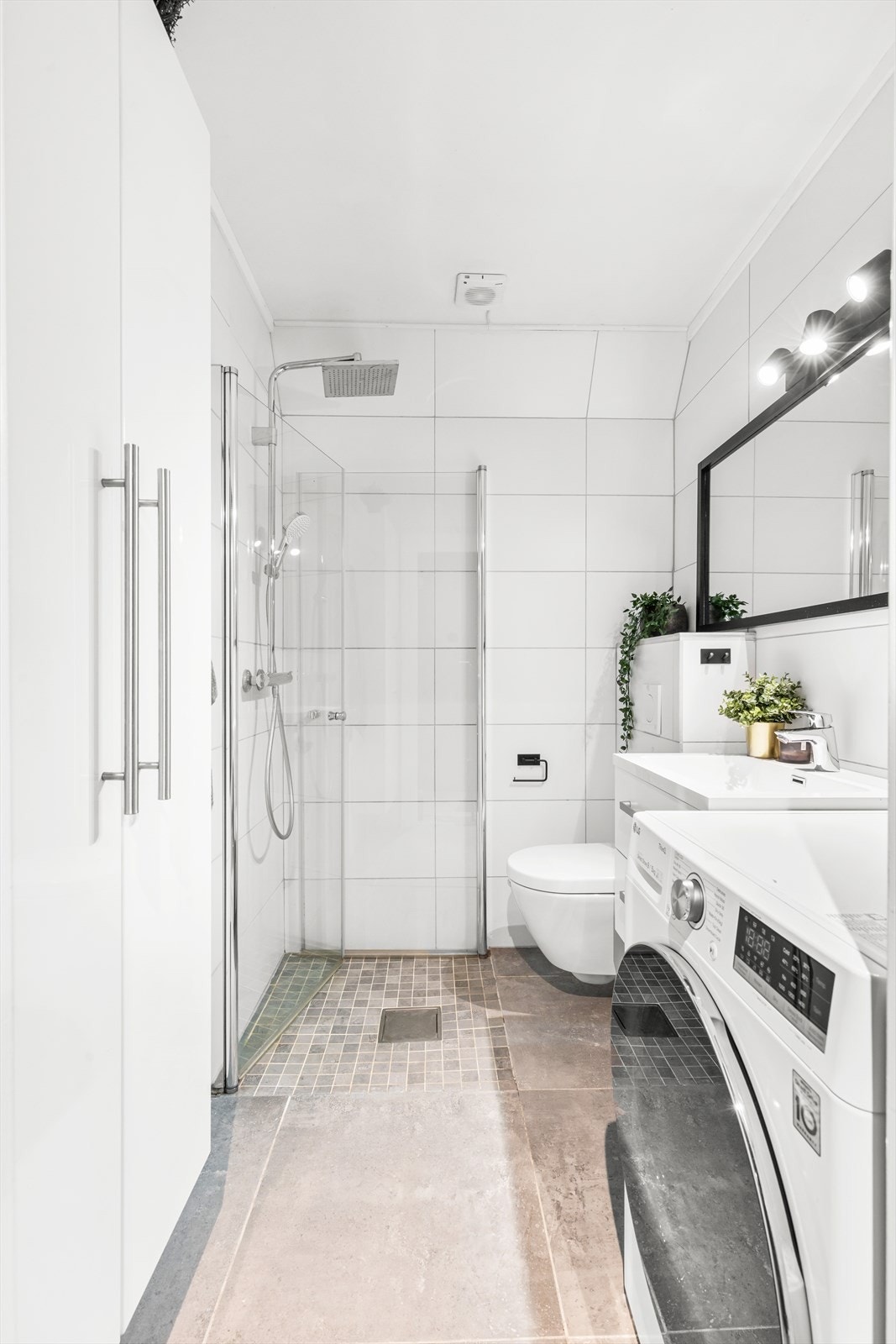 Innredningen består av servantskap, speil, vegghengt toalett og dusjhjørne Galleribilde