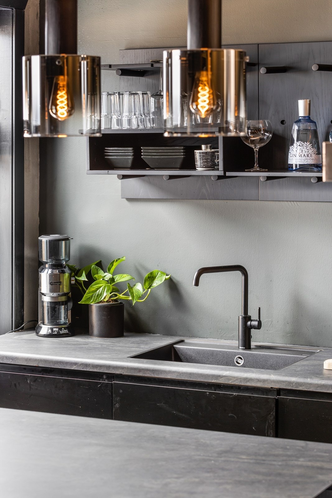 Innredningen med sorte fronter og laminert benkeplate med nedfelt oppvaskkum Galleribilde