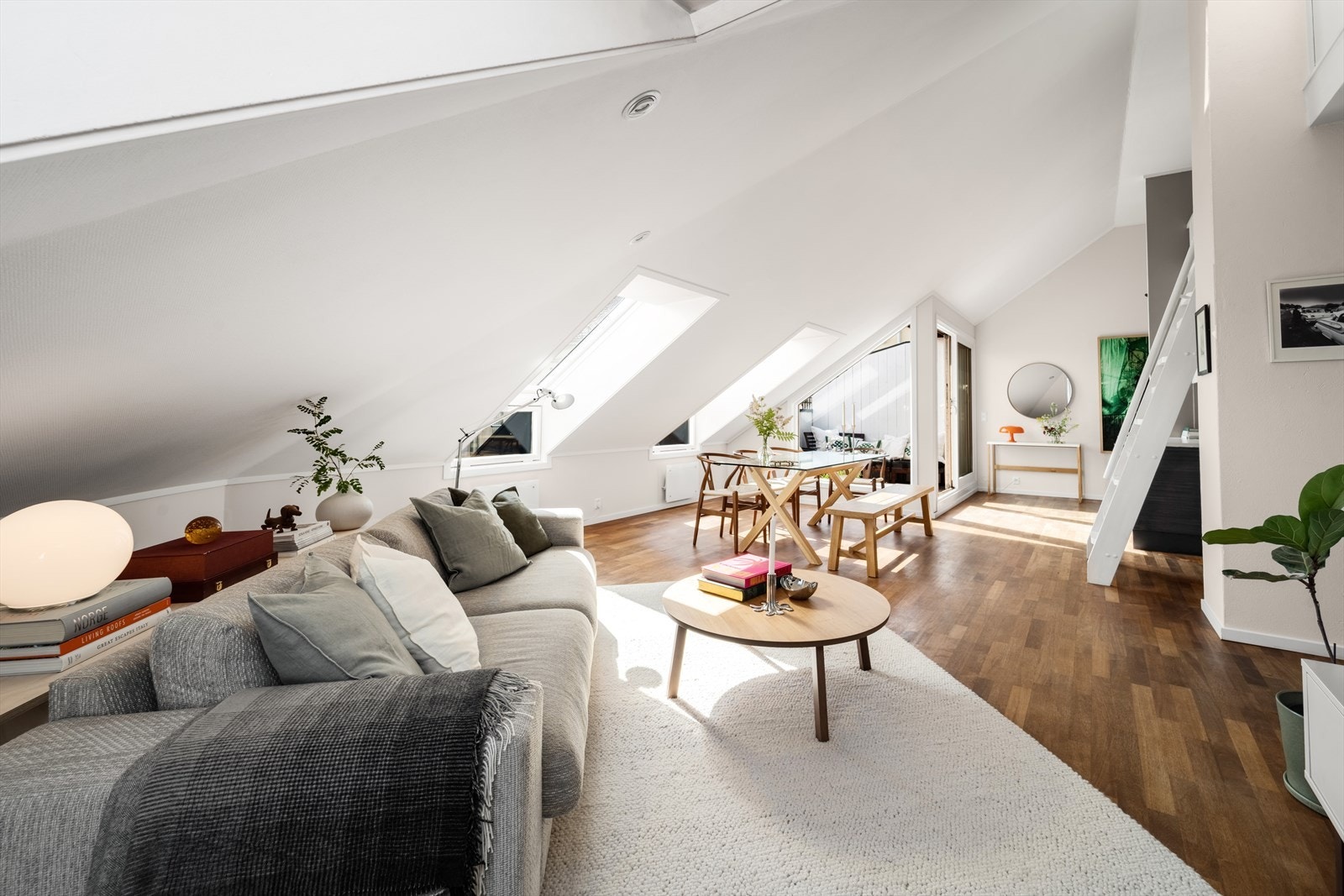 Gulvene er belagt med mørk trestavs parkett og står i stil med lyse fargevalg på malte plater på vegg og himling Galleribilde