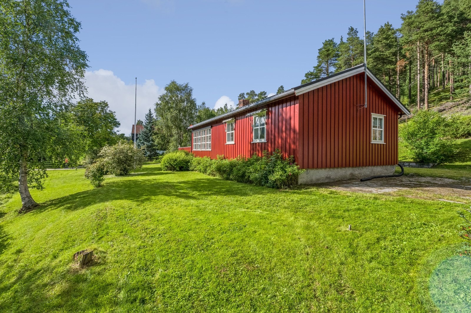 Boligen ligger på romslig tomt med gode solforhold. Tomten er pent opparbeidet med grøntområder, busker og trær. Galleribilde