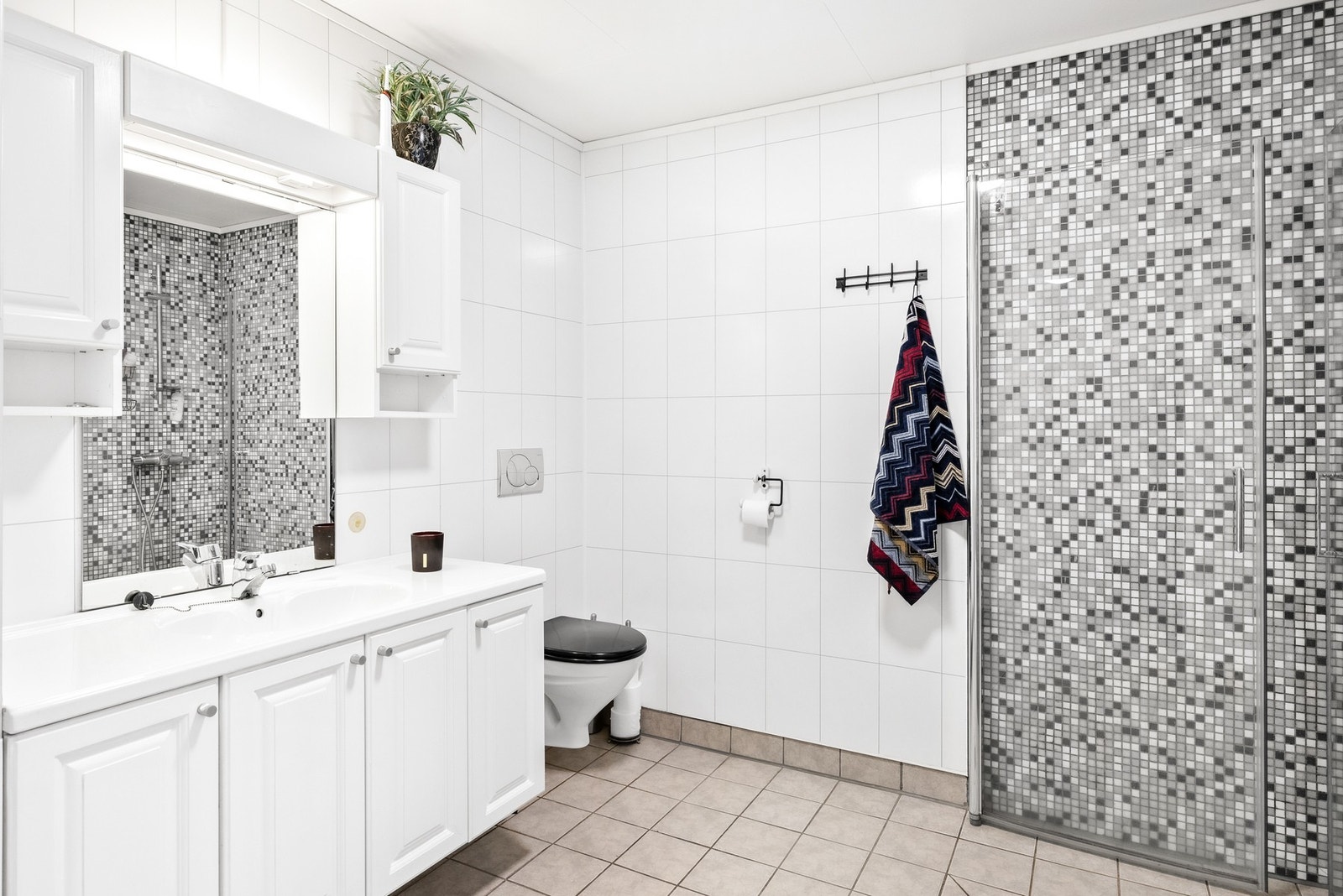 Badet har fliser på gulv og vegger med baderomsplater Galleribilde