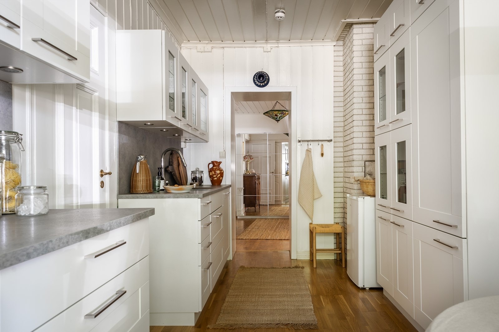 Benkeplaten er laget av slitesterkt laminat, og har en planlimt kum i rustfritt stål. En kullfilterventilator og alle de viktige apparatene som induksjonstopp, stekeovn, oppvaskmaskin og kjøl/fryseskap er integrert i kjøkkeninnredningen Galleribilde