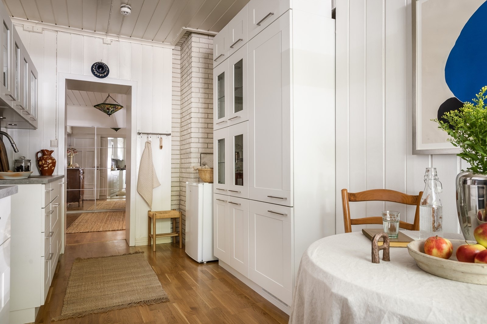 Kjøkkenet er utstyrt med en elegant kjøkkeninnredning som har profilerte fronter. Noen av overskapene har glassfronter, som legger til et snev av stil og gir mulighet til å vise frem dekorative elementer Galleribilde