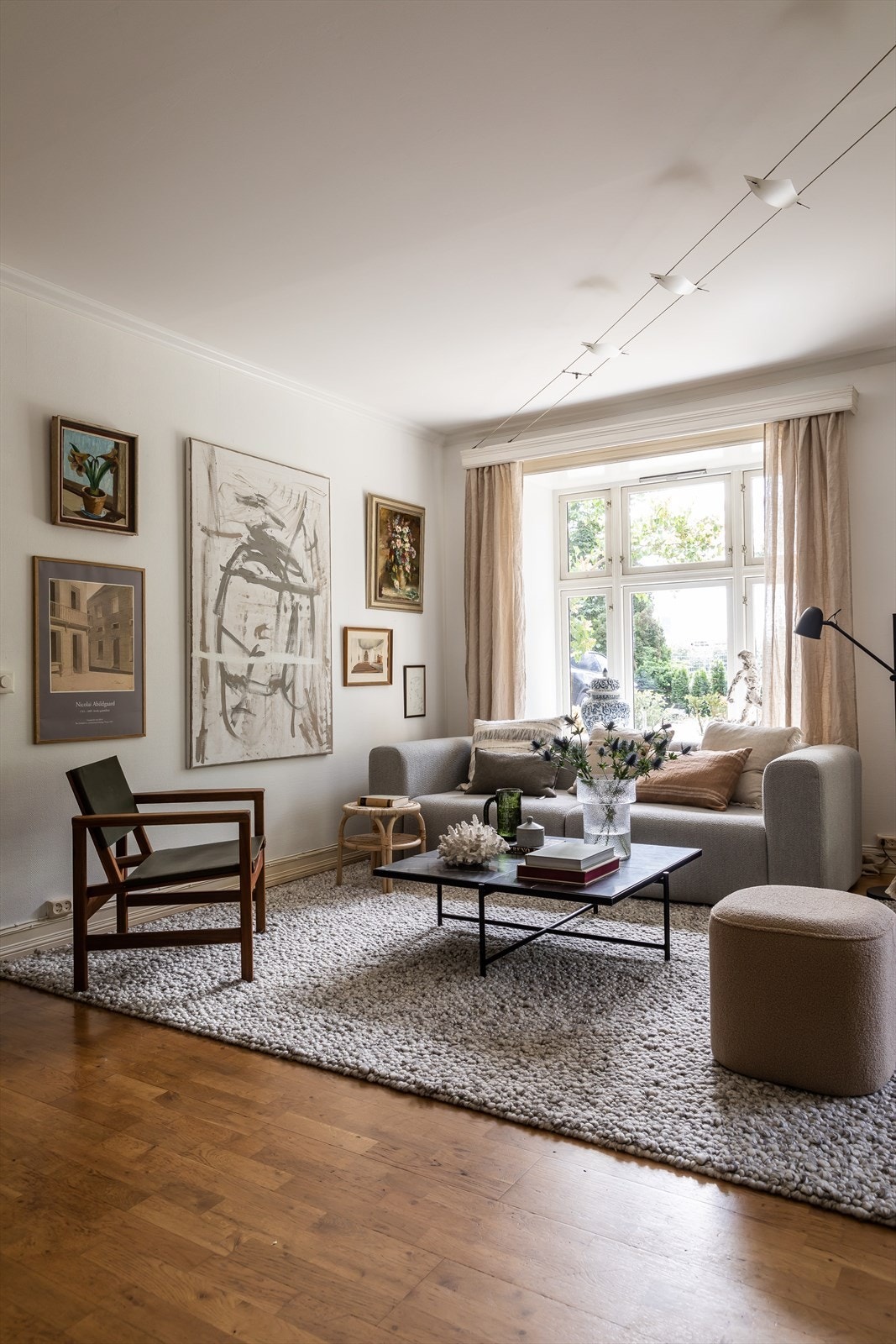 Boligens store vindusflater åpner opp for en betagende utsikt over et frodig grønt landskap Galleribilde