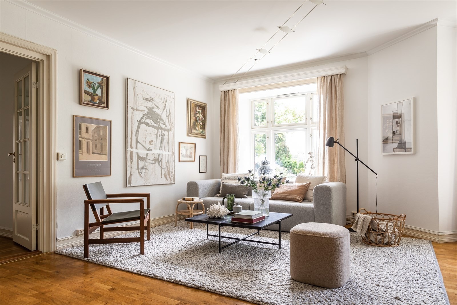 Boligens store vindusflater åpner opp for en betagende utsikt over et frodig grønt landskap Galleribilde