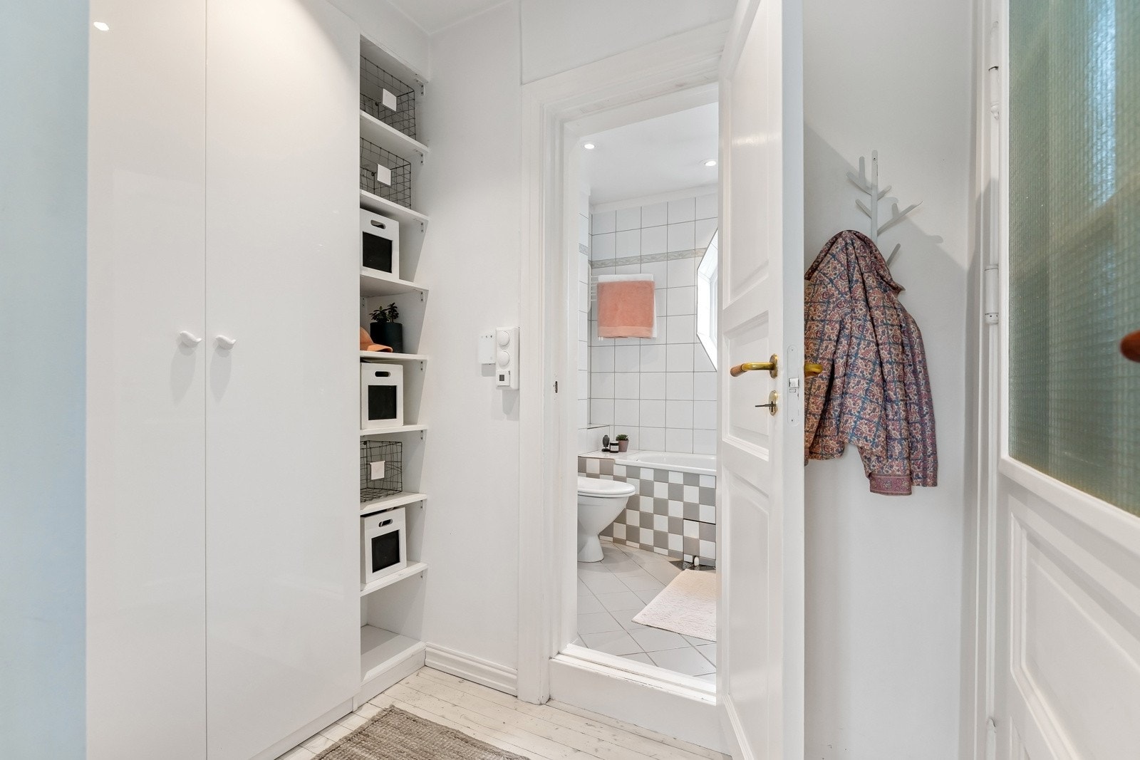 Entreen er innbydende med malt tregulv og hvitmalte vegger. Rommet er smart innredet med garderobeskap og hyller som gir godt med oppbevaringsplass. Galleribilde