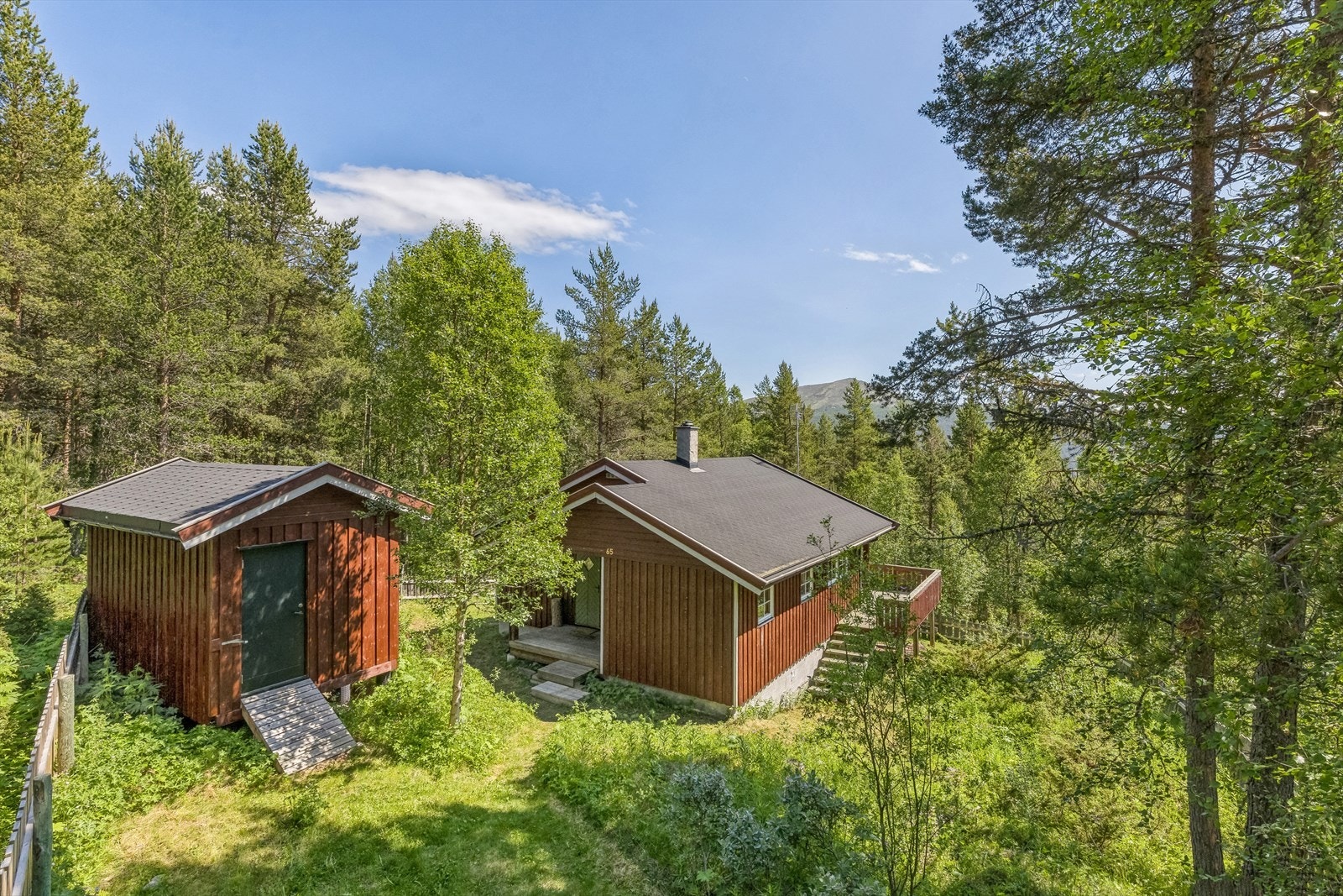 Sjarmerende og trivelig hytte med tilhørende uthus, fint beliggende i Lusetermorkje i Heidal. Galleribilde