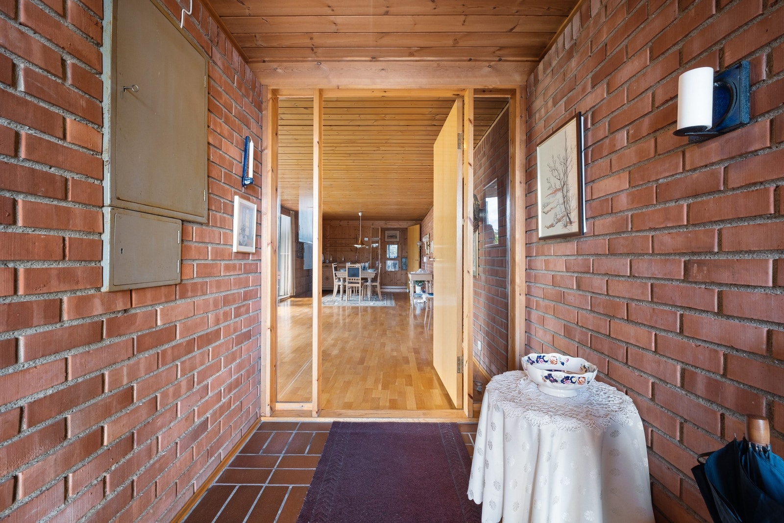 Entréen har murte vegger, og en dør med sidefelt av glass som skille til stuen. Galleribilde