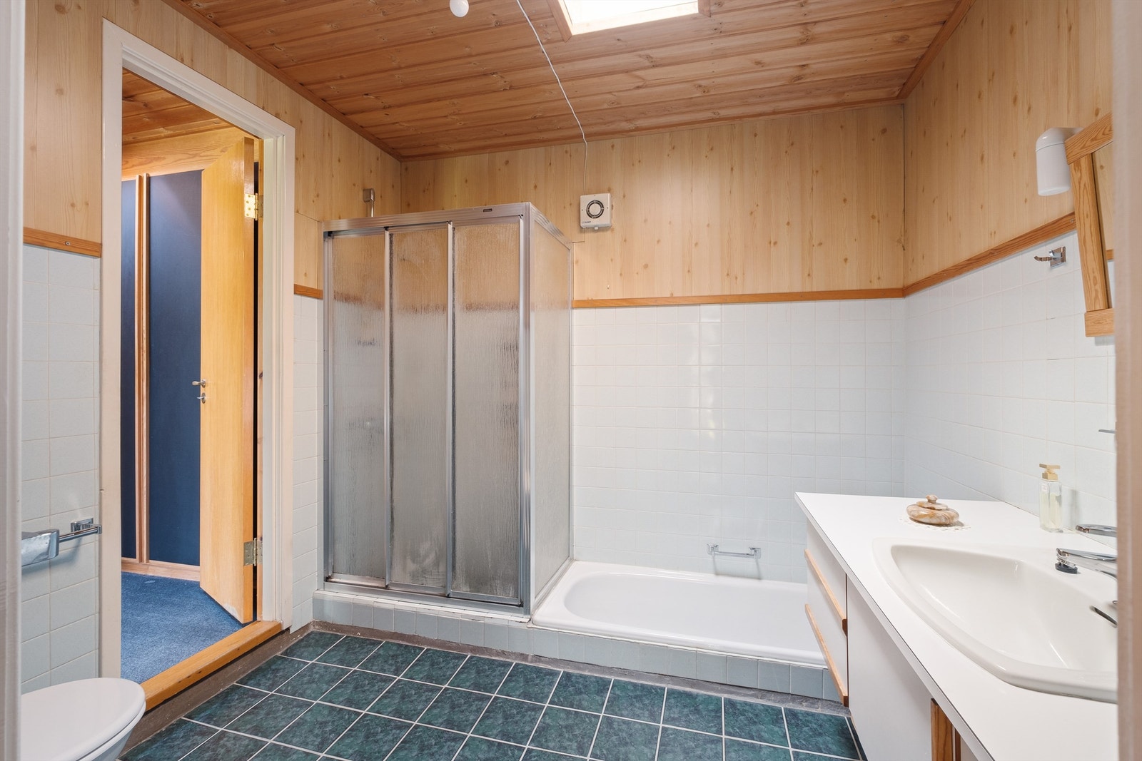 Videre har rommet et nedsenket badekar og dusj på flis. Galleribilde