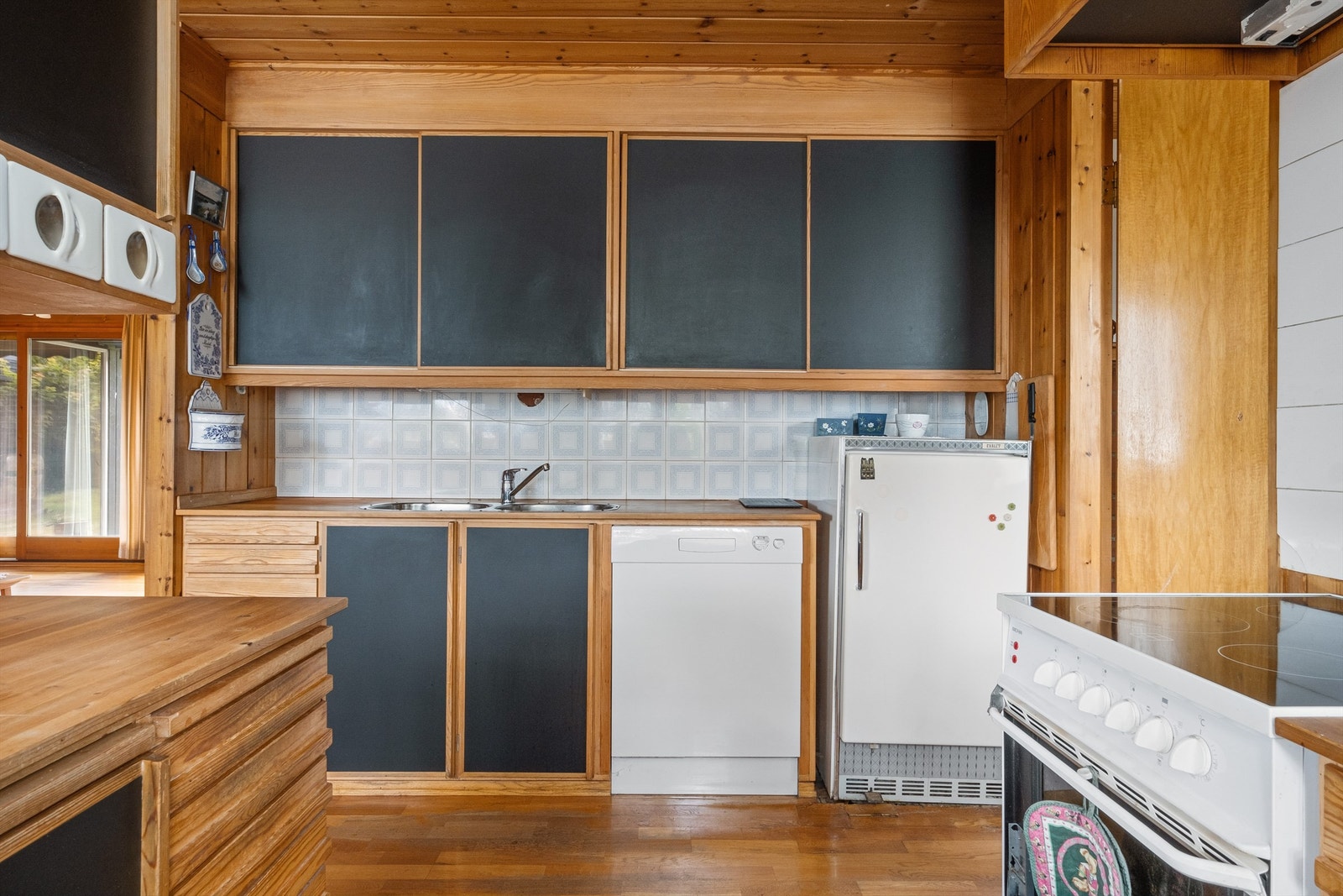 Kjøkkenet har fliser mellom benkeplate og overskap, og det er gode arbeidsflater for kokken. Galleribilde