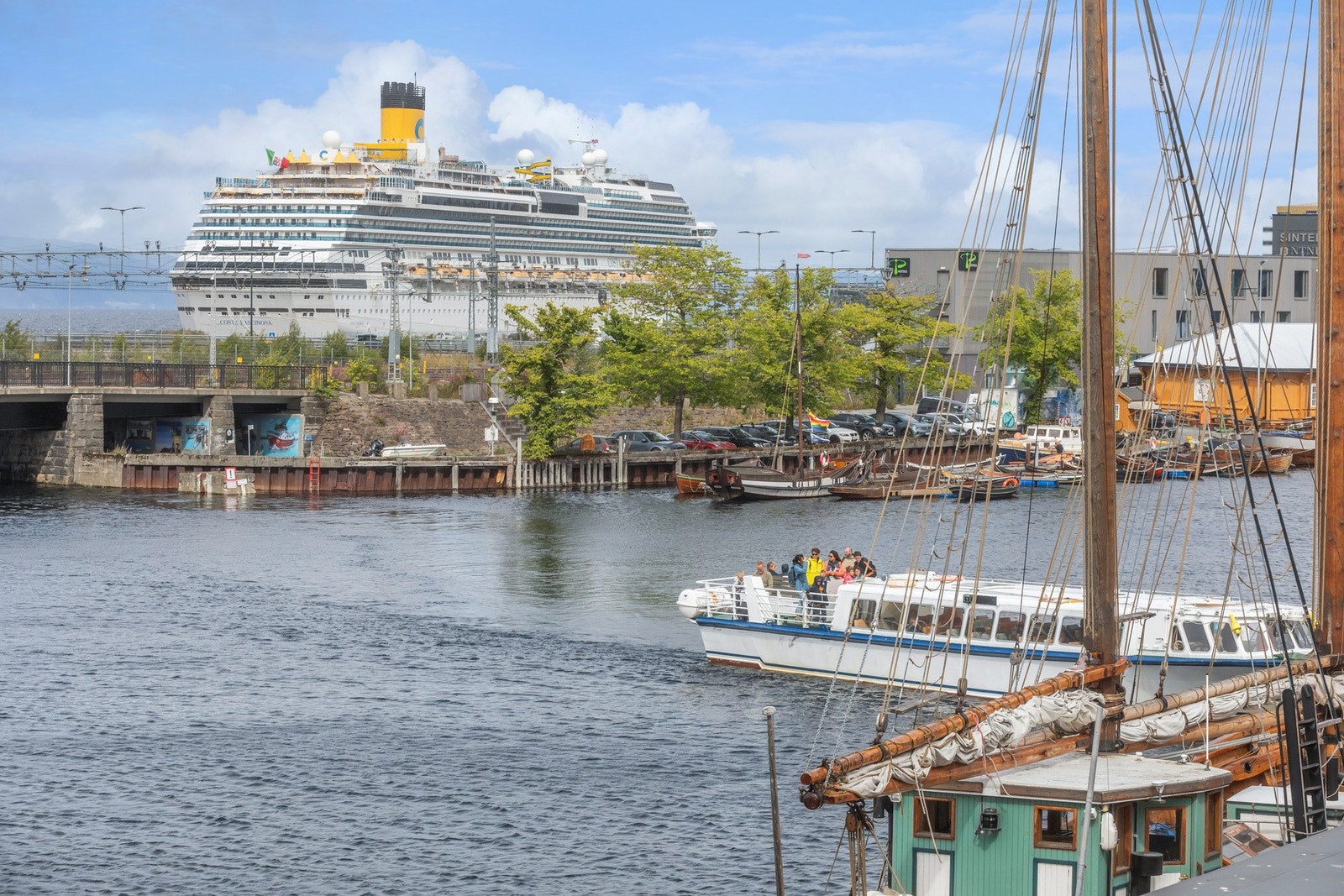 Nyt synet av livet i kanalen og ute på fjorden. Her med Munkholmbåten og et større cruiseskip som ligger til kai på piren. Galleribilde