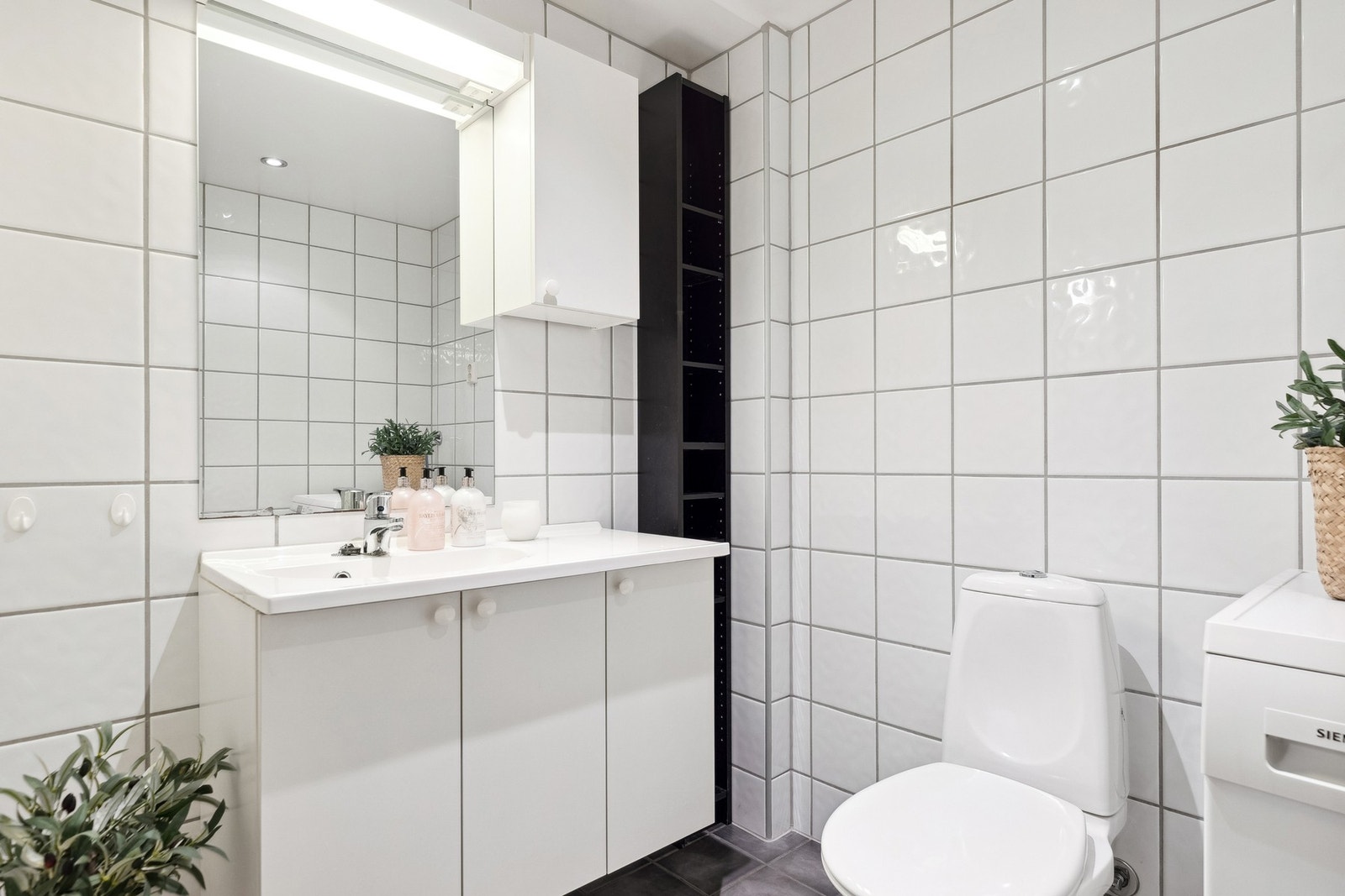 Delikat flislagt bad med opplegg for vaskemaskin og godt med skapplass. Downlights i himling. Galleribilde