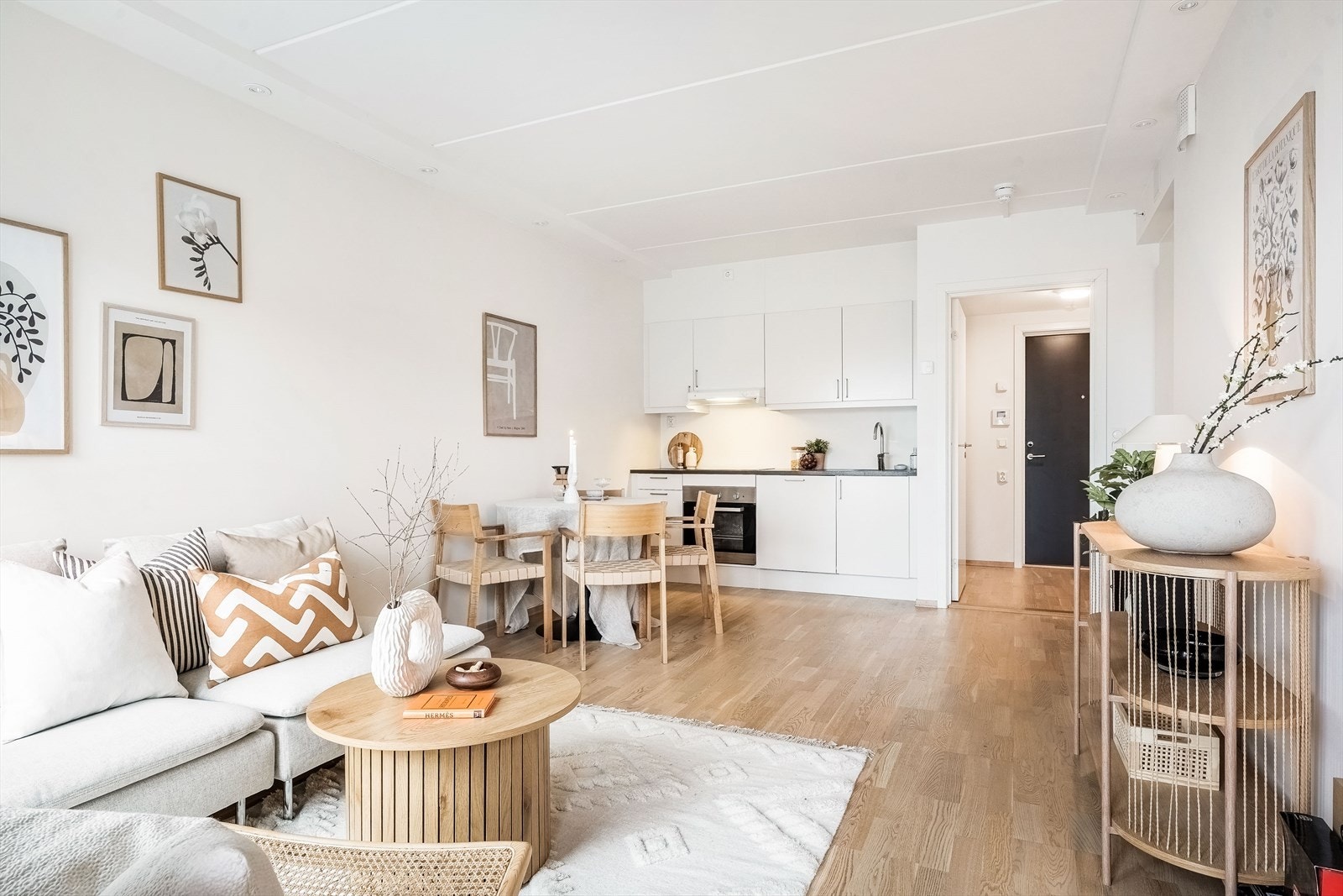 Stue med åpen løsning mot kjøkken med god plass til sofaseksjon med tilhørende møblement, TV-benk og spisebord. Galleribilde