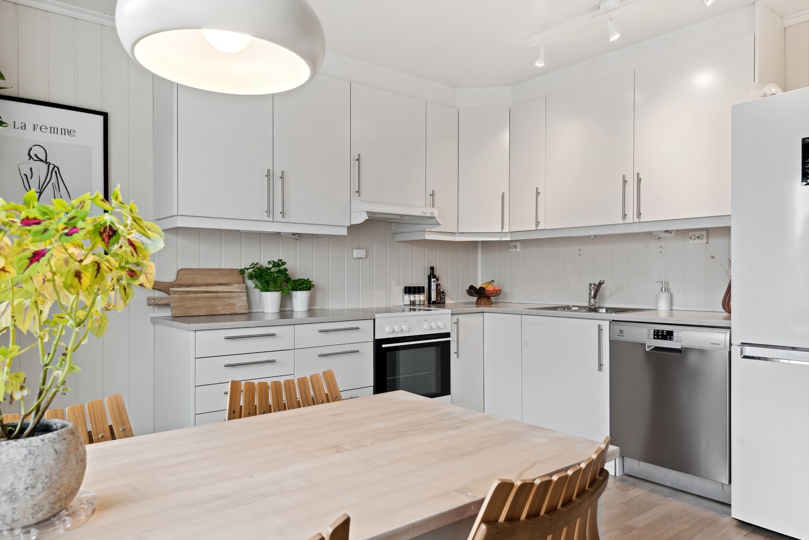 Innredningen har lyse glatte fronter og laminert benkeplate med nedfelt oppvaskkum. Praktisk med takhøye overskap med belysning under. Galleribilde