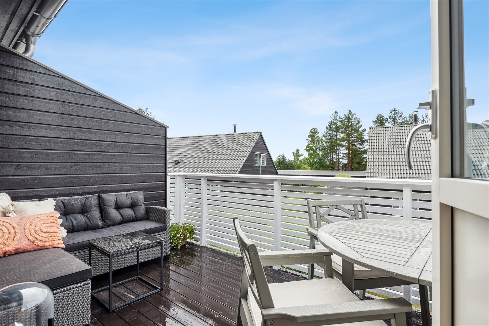 Balkongen har impregnerte terrassebord på gulv, beiset- malt rekkverk og levegg mot naboen. Galleribilde