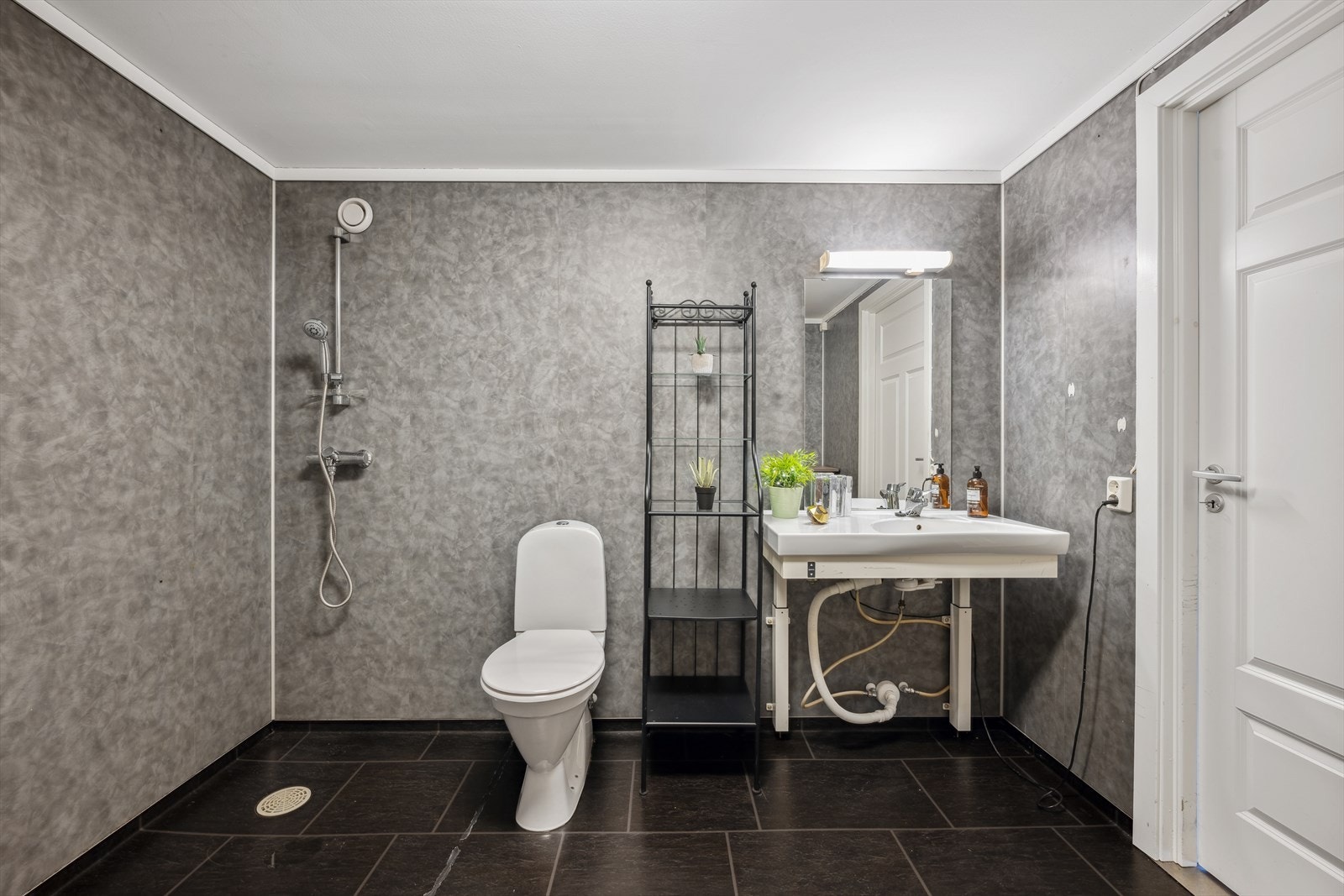 Romslig bad med vask, dusj, wc og opplegg for vaskemaskin. Galleribilde