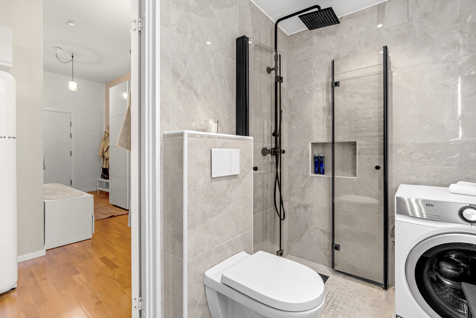 Lekkert, flislagt baderom med varmekabler i gulv og opplegg for vaskemaskin. Galleribilde