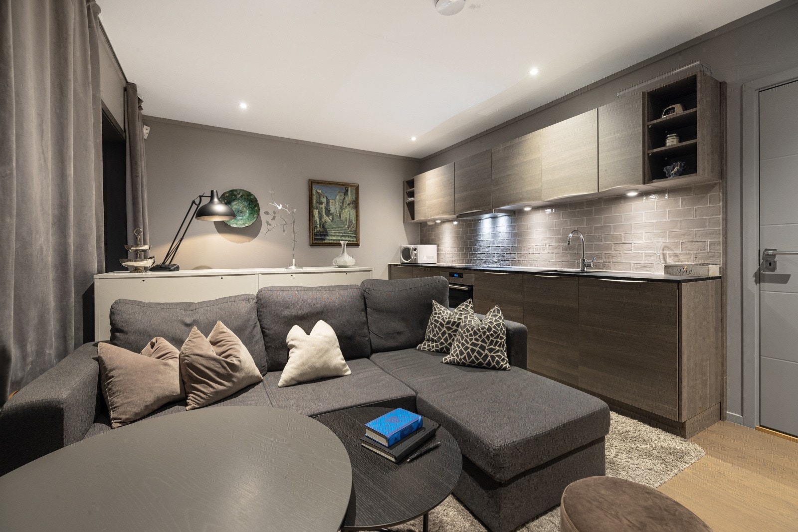 Gjestedel har innredet kjøkken med glatt innredning, fliser over benk, downlights under overskap, laminat benkeplate med planlimt kum og nedfelt induksjonstopp, Integrert komfyr, oppvaskmaskin og kjøleskap. Galleribilde
