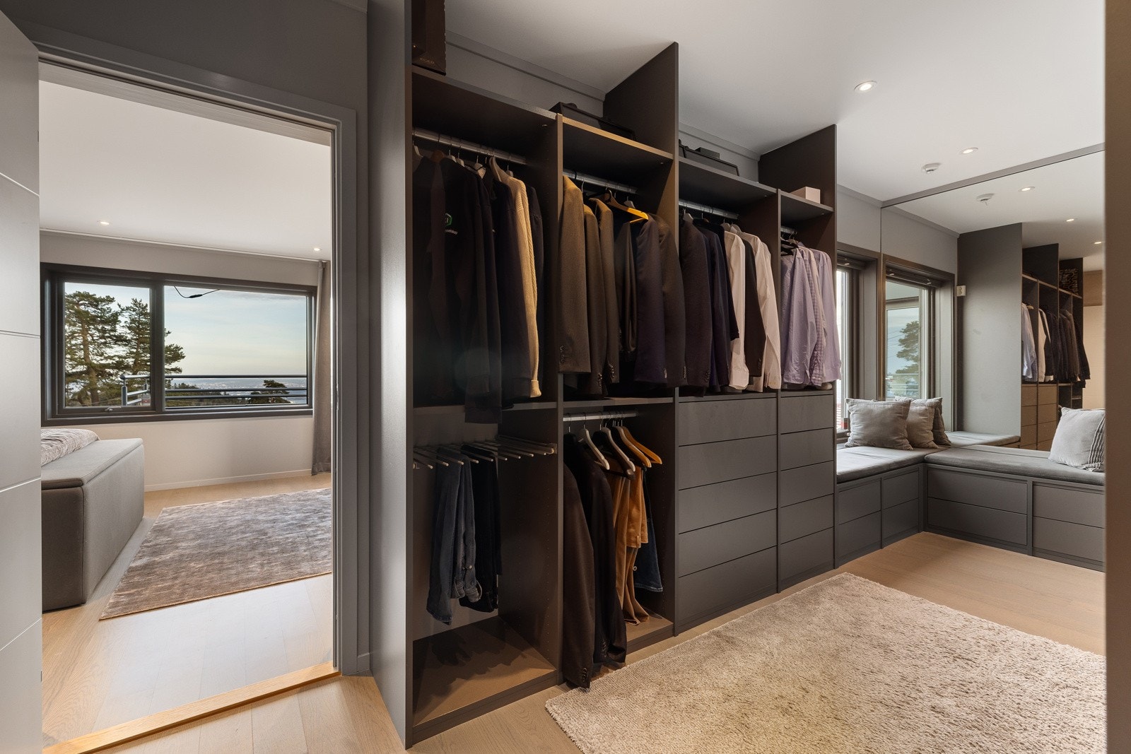 Stor walk-in garderobe i forbindelse med hovedsoverommet, med plassbygd innredning. Galleribilde