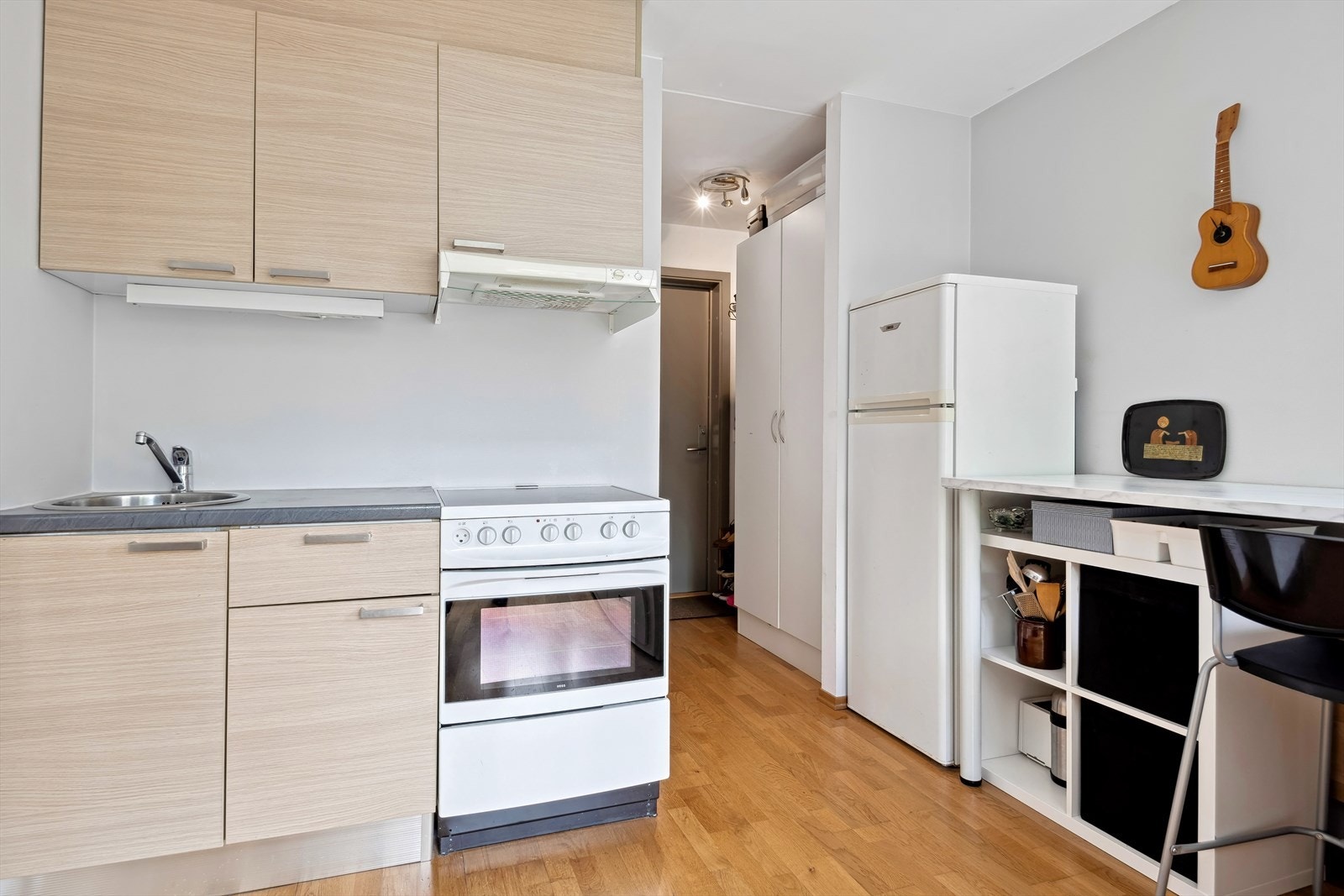 Utleiedel - Aran kjøkkeninnredning med slette fronter, laminat benkeplate, oppvaskkum, kjøkkenventilator og frittstående komfyr, kjøl og frys. Galleribilde